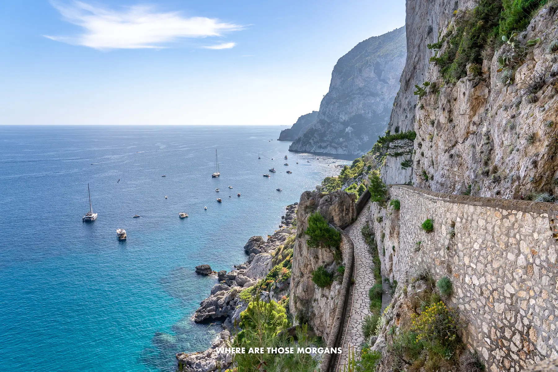 Photo of a cliffside walking path switchbacking sharply with the sea to one side