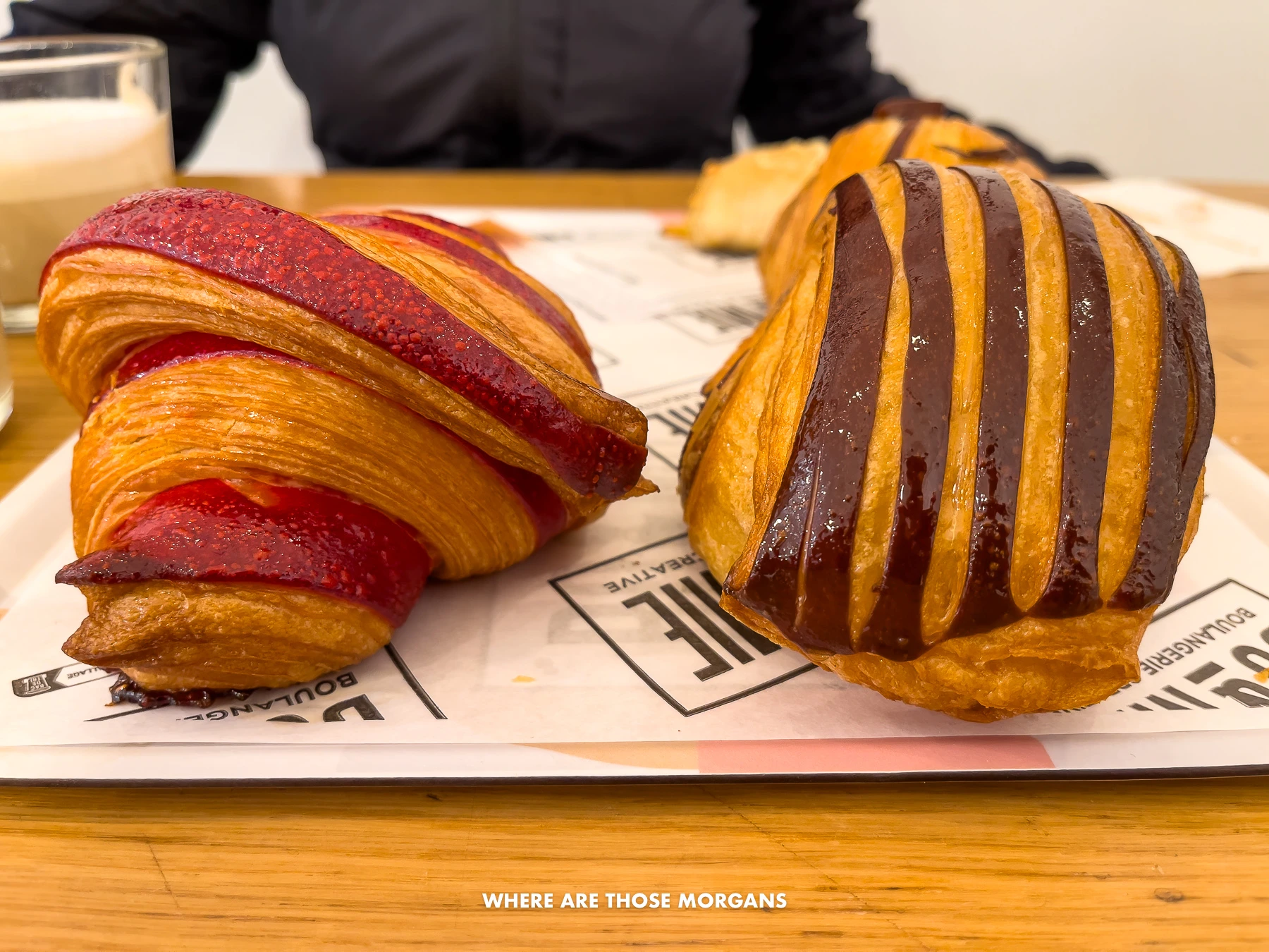 Photo of artsy croissants one chocolate one raspberry on a tray