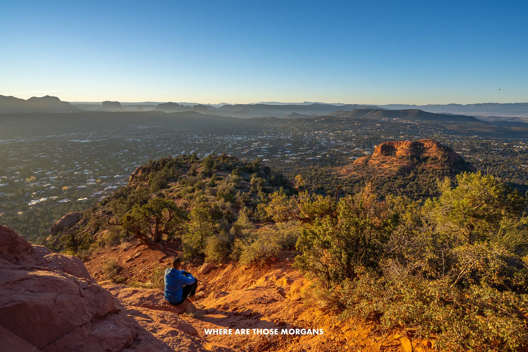Photo of Mark Morgan sat watching a sunrise over Sedona's vast red rock landscape