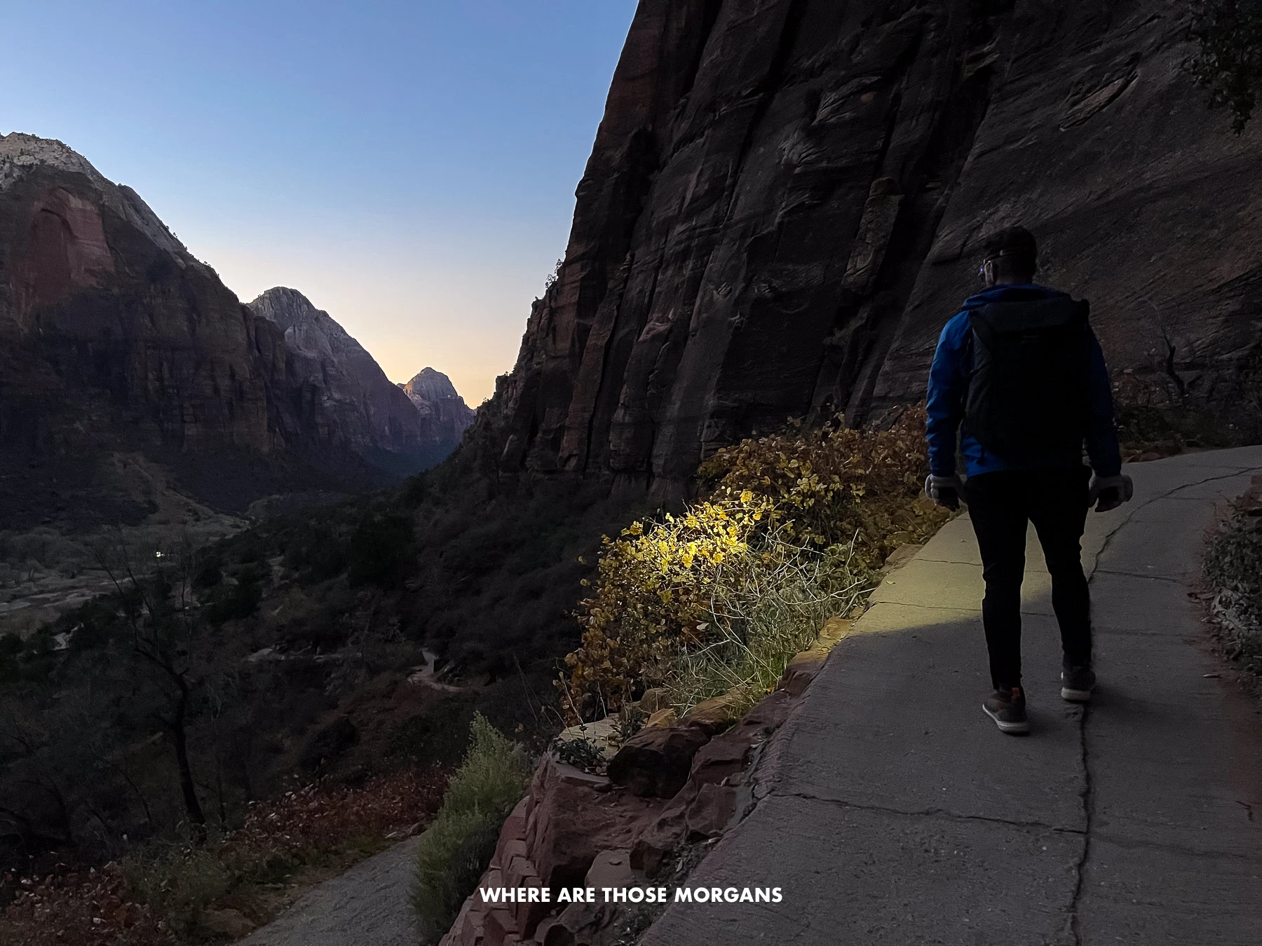 Man hiking Angels Landing at dusk with a headlamp