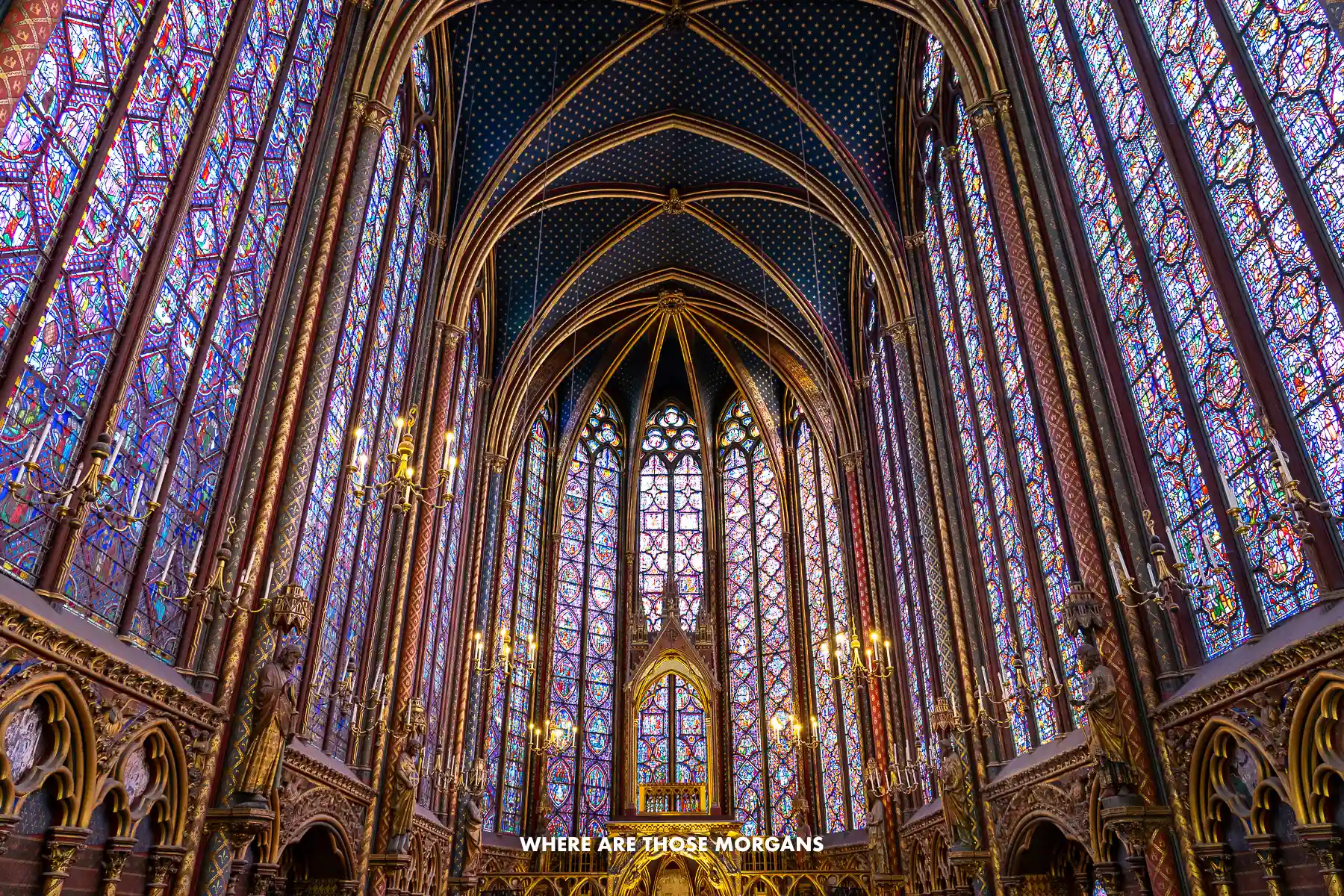 Photo of the purple colored interior of Sainte-Chapelle in Paris with large stained glass panels
