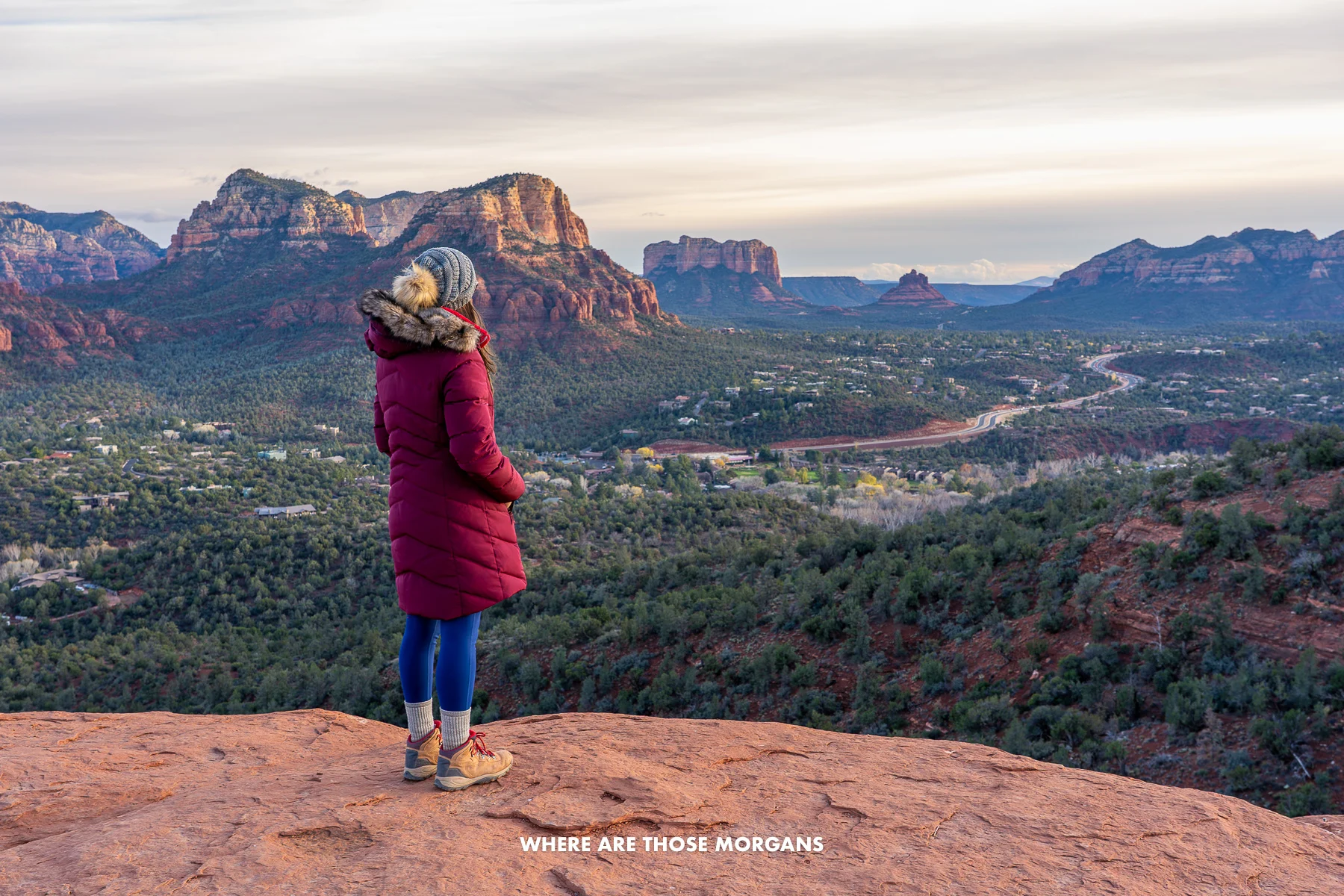 Photo of Kristen from Where Are Those Morgans in a winter coat and hat standing on red rocks looking out at south Sedona