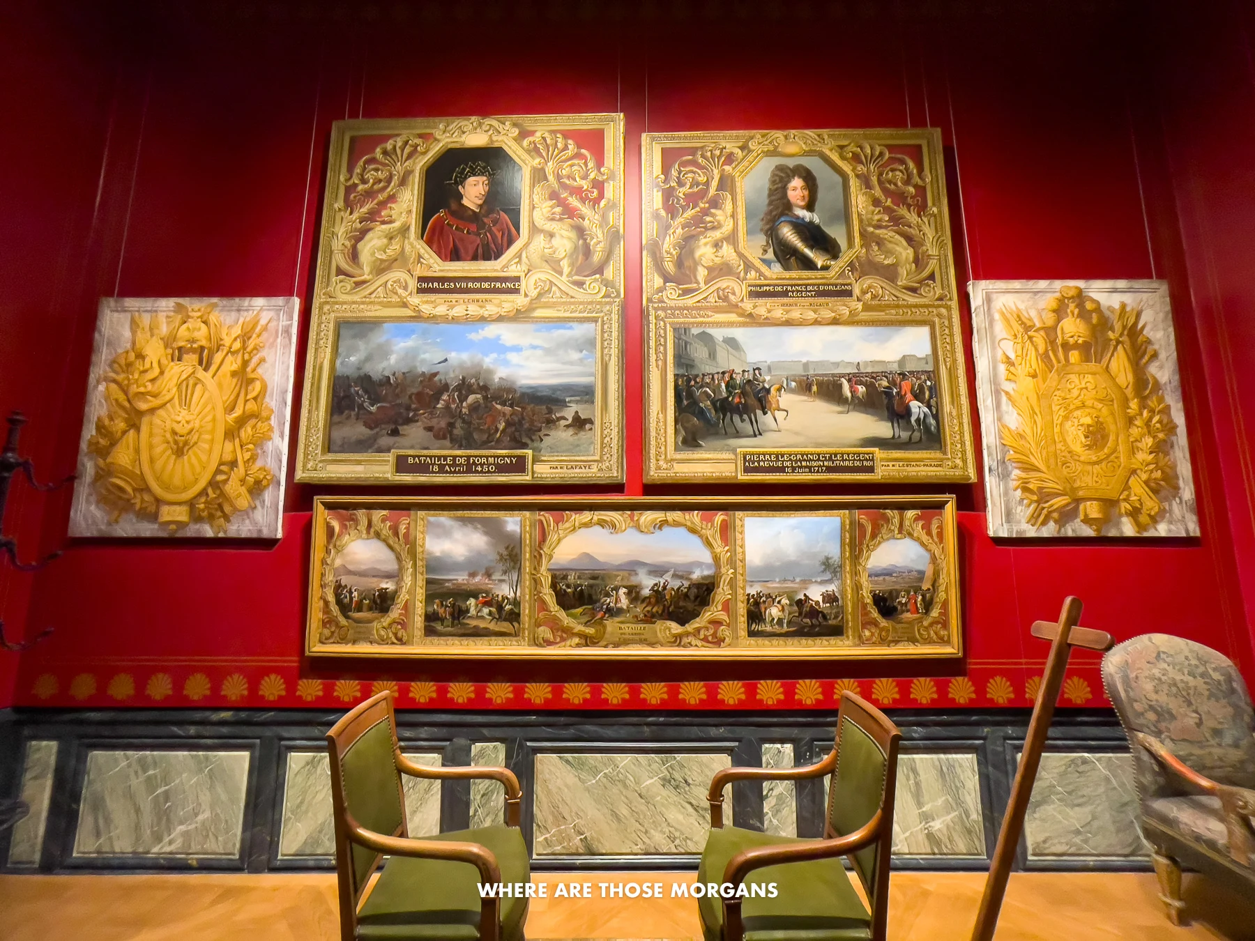 Paintings and artifacts in a dark room with red walls at a museum in France