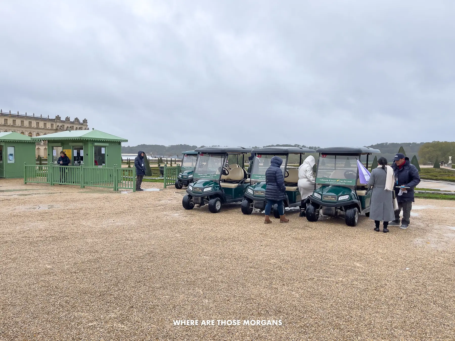 Golf carts for rent in the grounds of a tourist attraction near Paris on a cloudy day