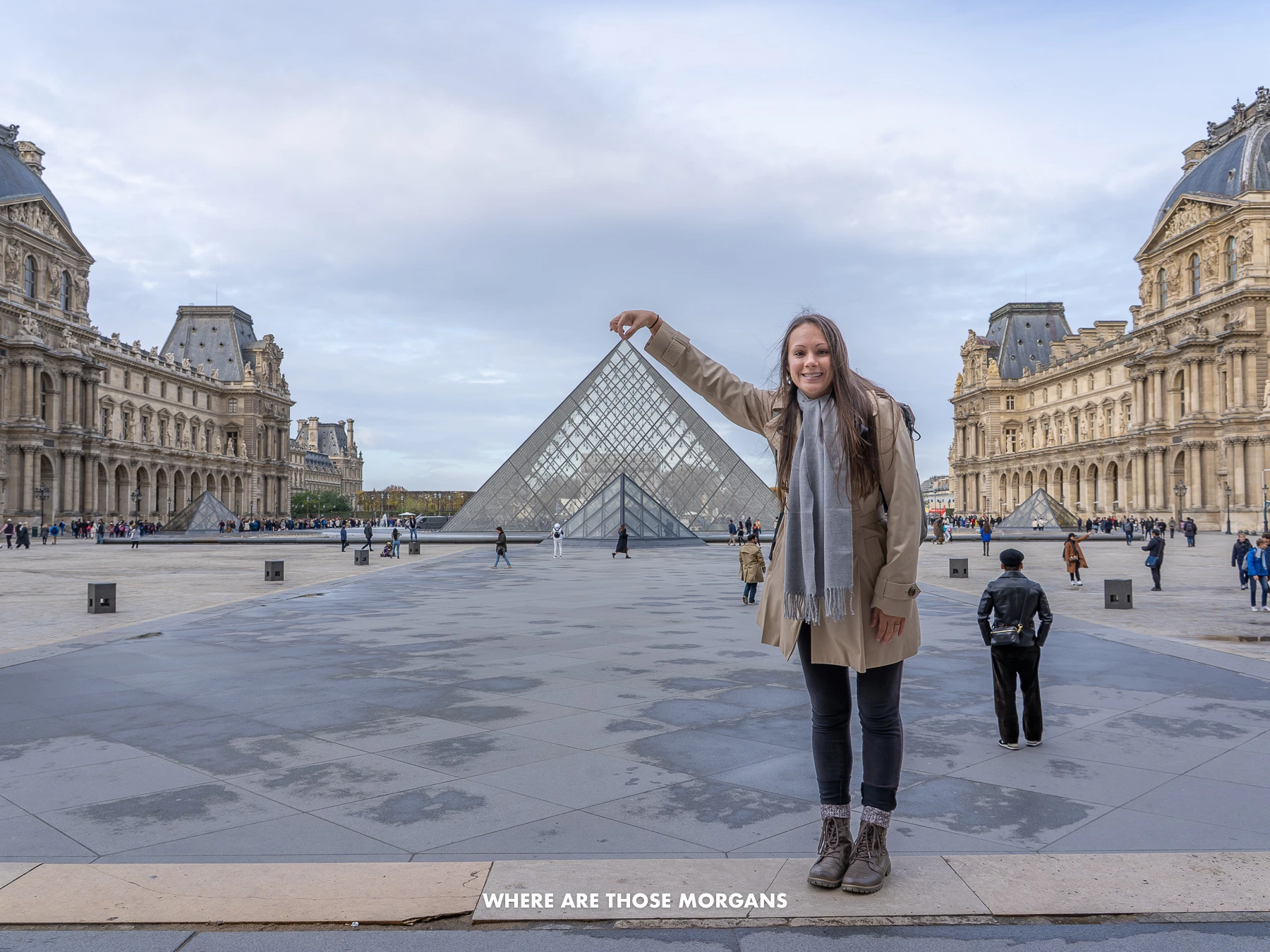 Photo of Kristen from Where Are Those Morgans pinching the top of the glass pyramid at the Louvre Museum