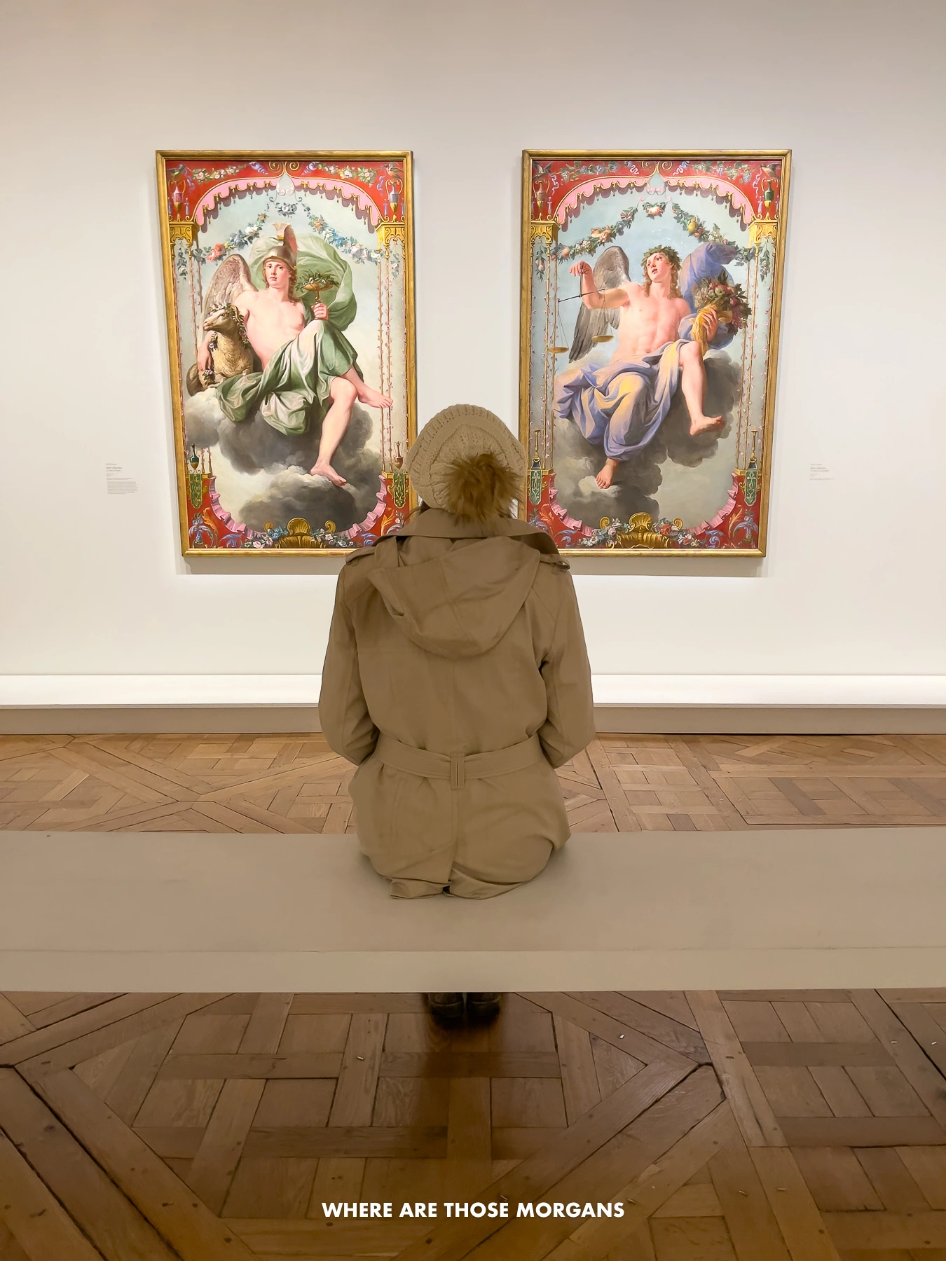 Kristen from Where Are Those Morgans sat on a white bench looking at two paintings on a white wall