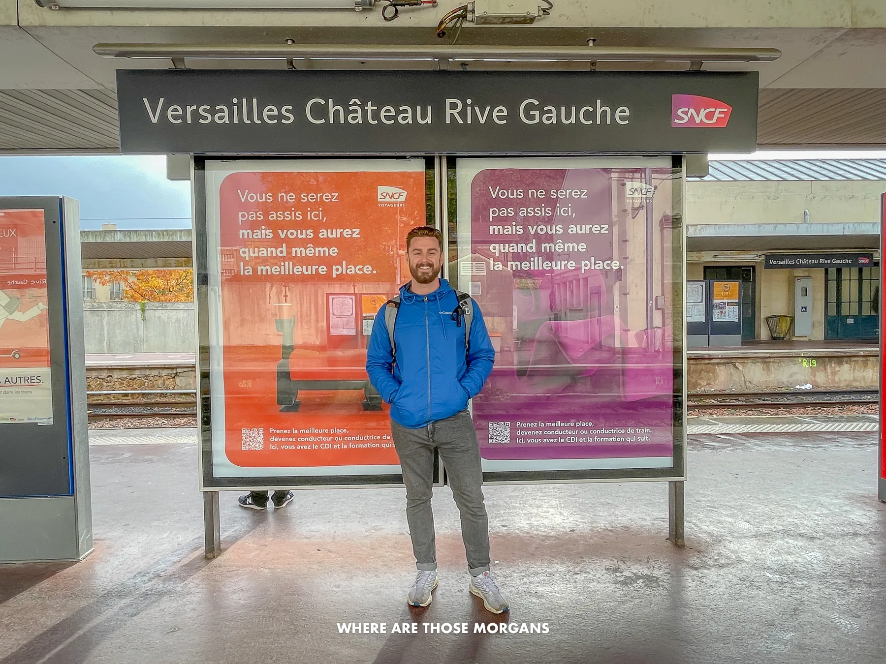 Mark from Where Are Those Morgan standing underneath a sign at Versailles Chateau Rive Gauche train station near Paris