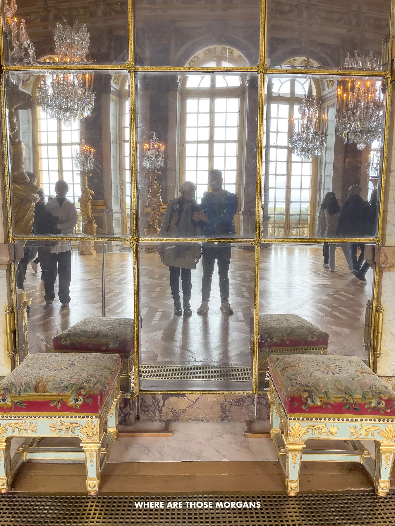 Mark and Kristen from Where Are Those Morgans taking a photo of themselves in a mirror inside the Palace of Versailles