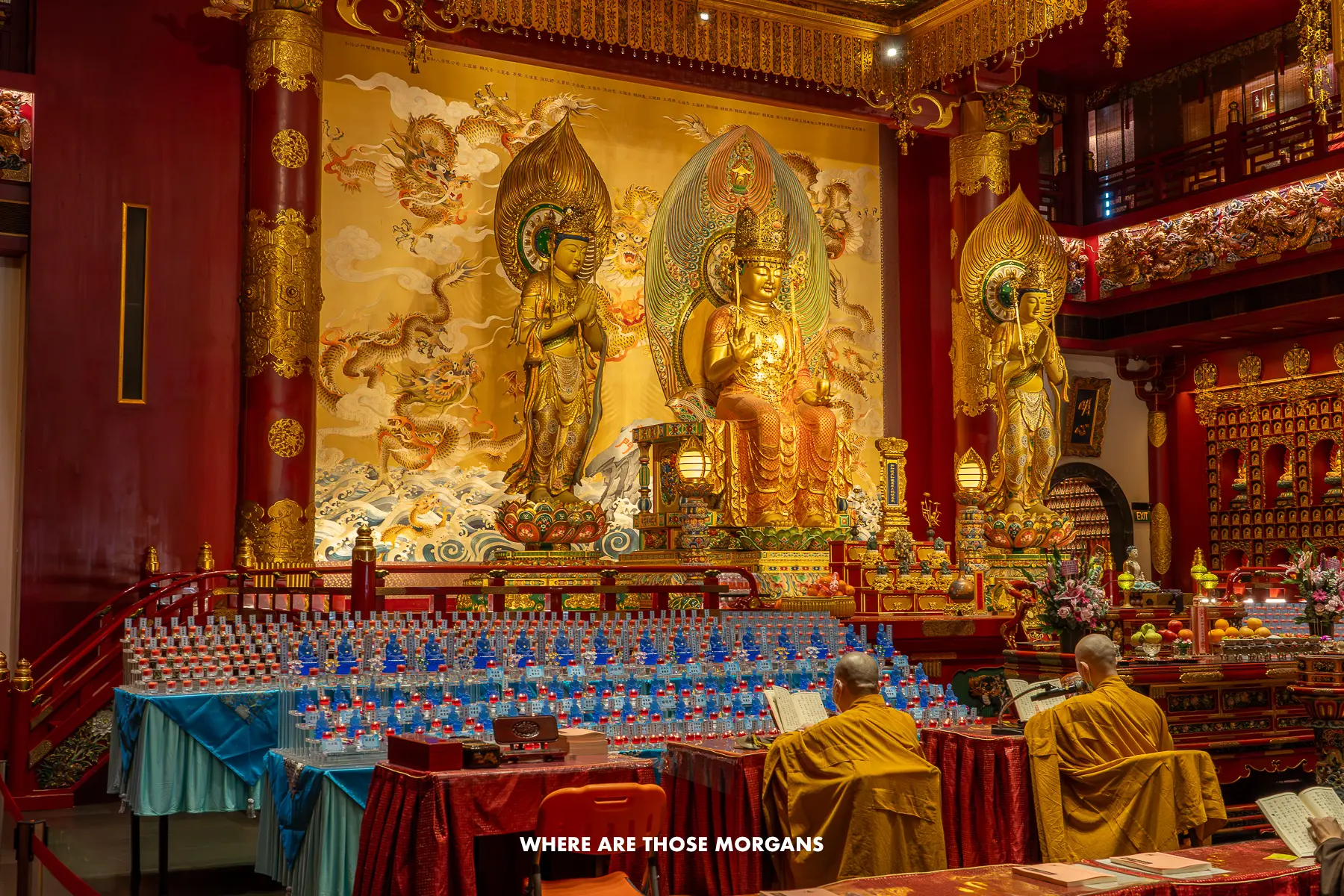 Inside a Buddhist Temple in Singapore with gold decoration and monks sat near the front