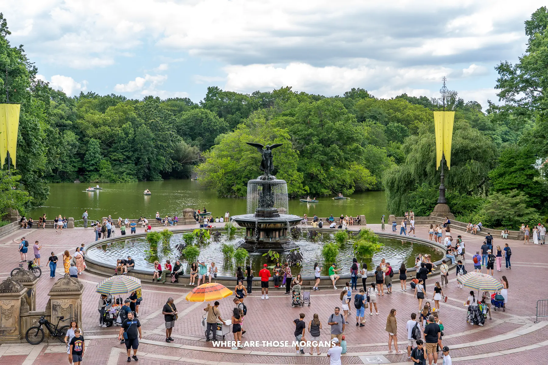 Bethesda Fountain in Central Park New York in the summer with tourists gathering around the water and lush green leaves in trees