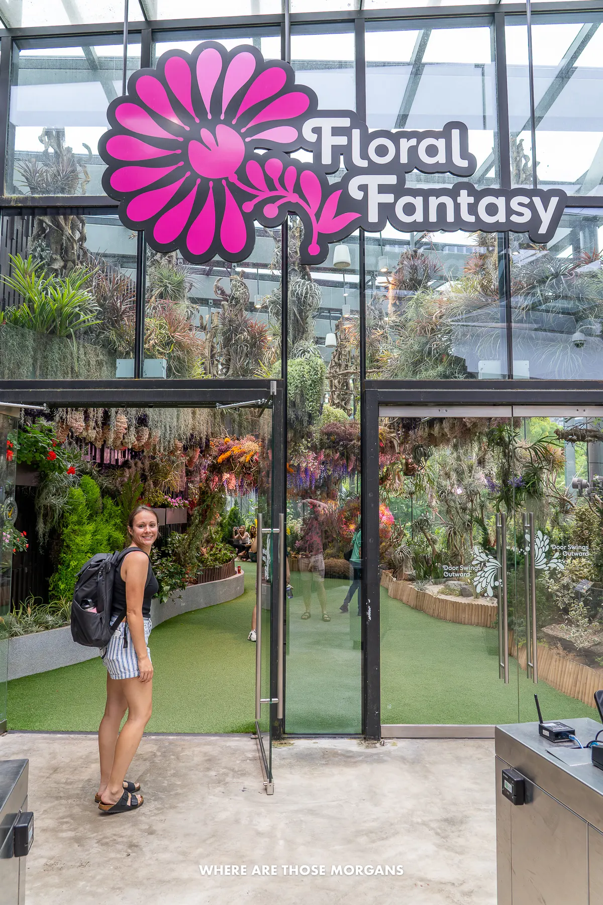 Kristen from Where Are Those Morgans entering a glass building with flowers inside and the words Floral Fantasy above