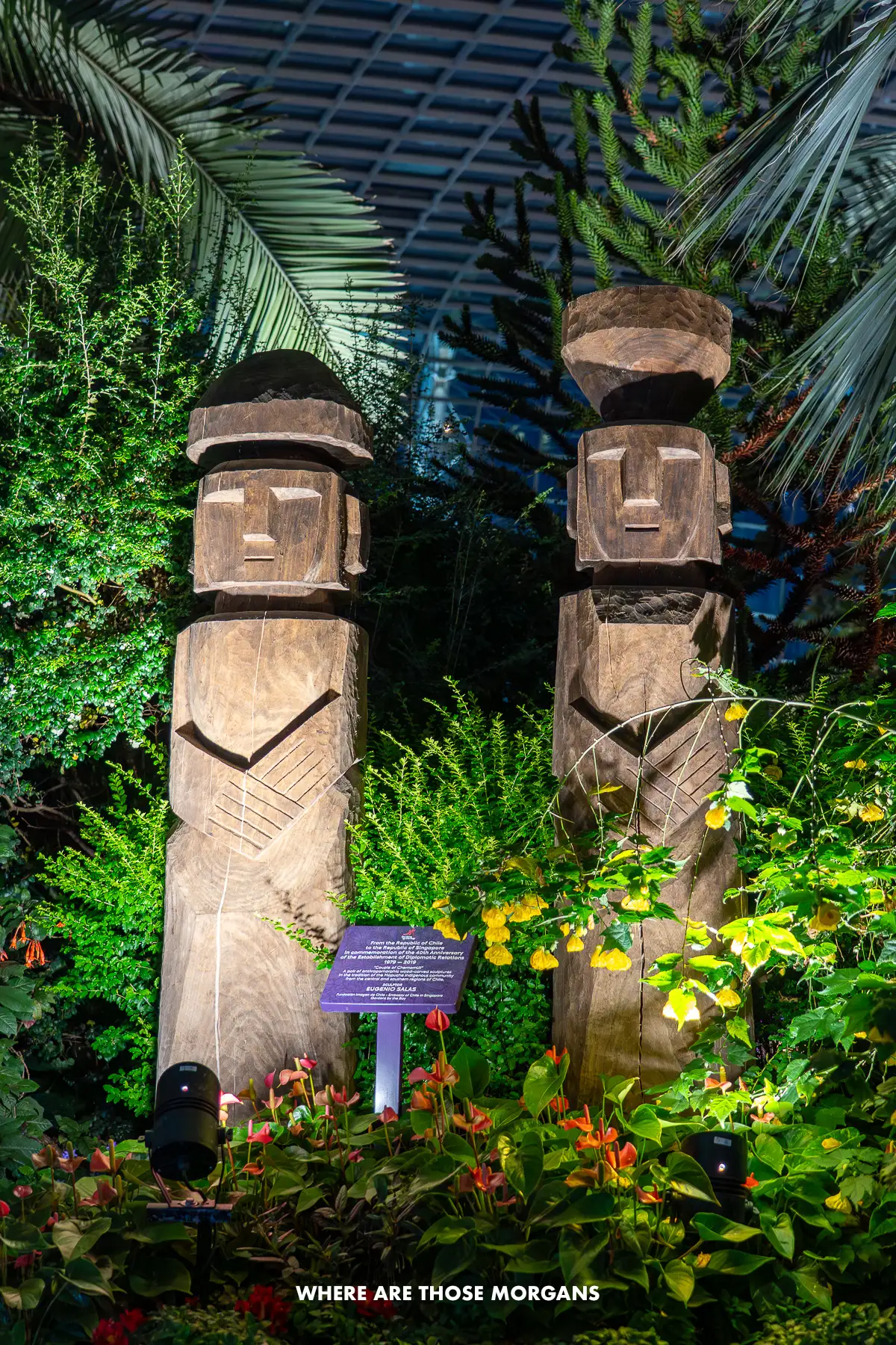 Two Moai statues in a flower garden in Singapore at night