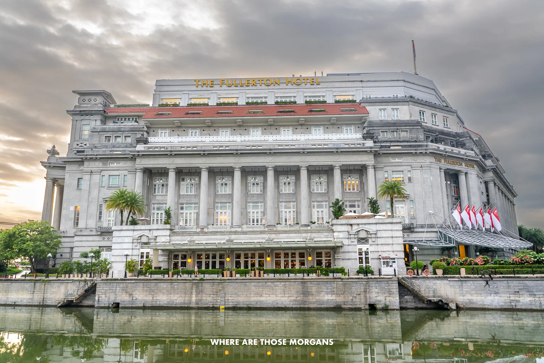 Looking at the grand colonial Fullerton Hotel across the Singapore River with clouds in the sky