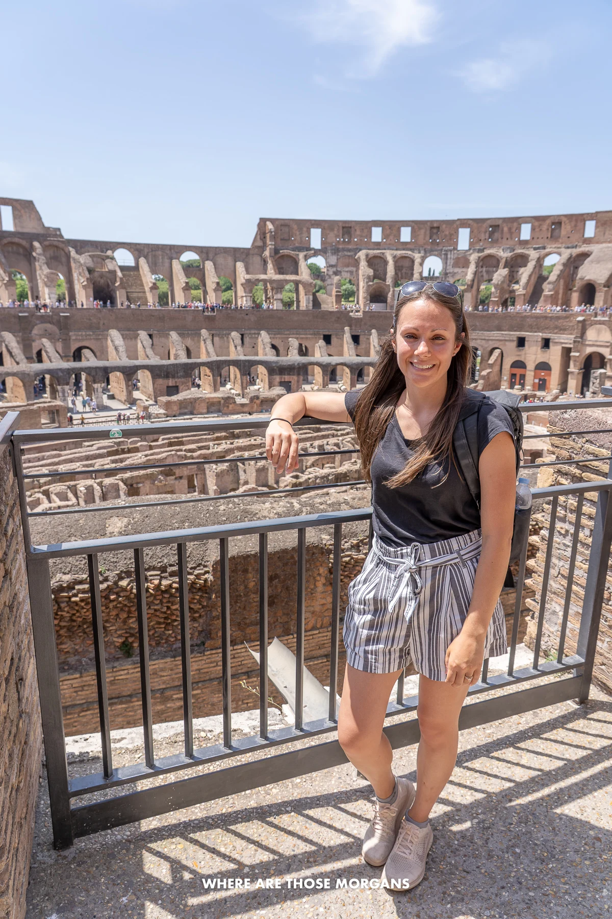 Kristen from Where Are Those Morgans standing on a small balcony over looking the Colosseum in Rome on a hot day