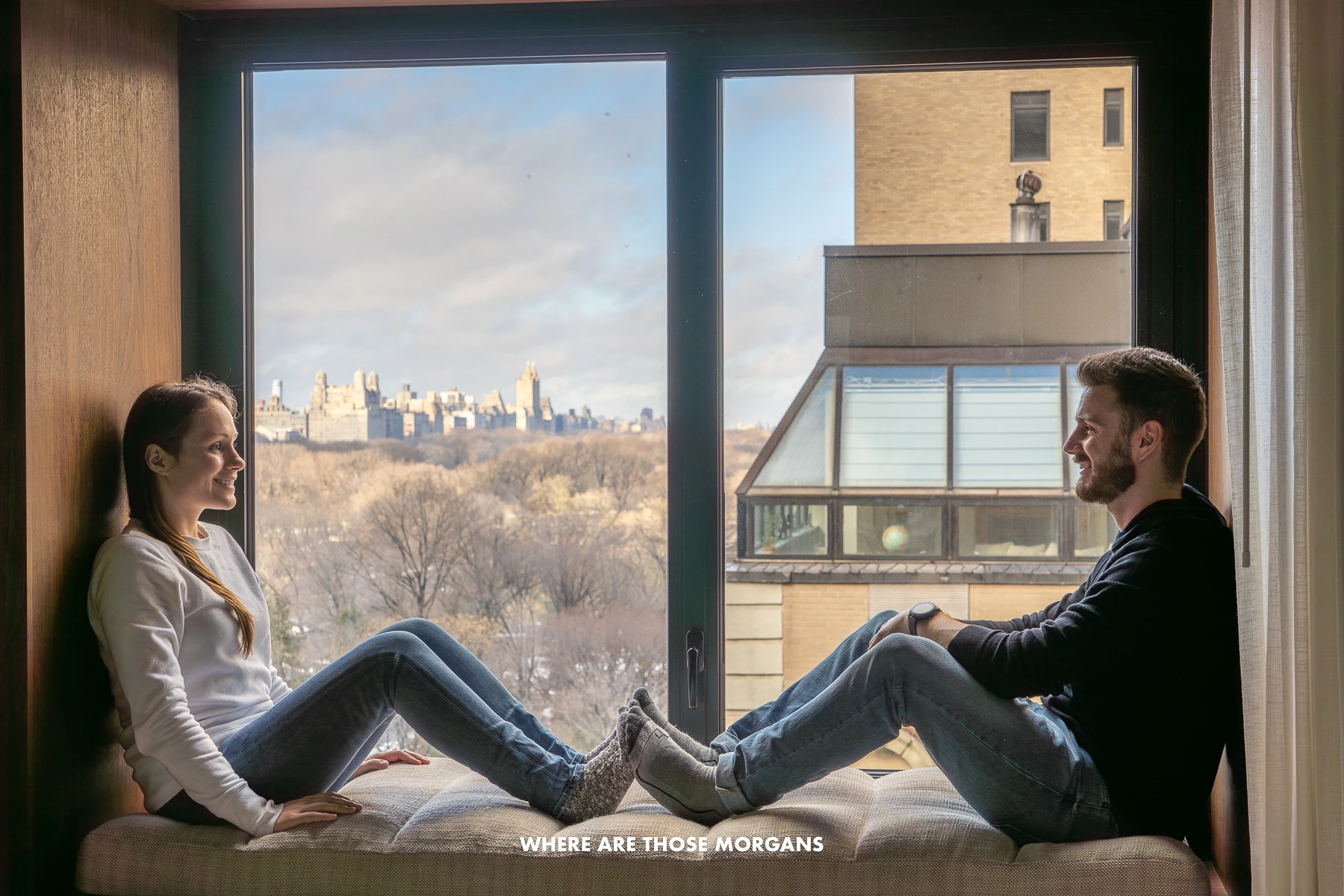 Mark and Kristen from Where Are Those Morgans sat on a window seat opposite each other with views out of an NYC hotel window overlooking Central Park