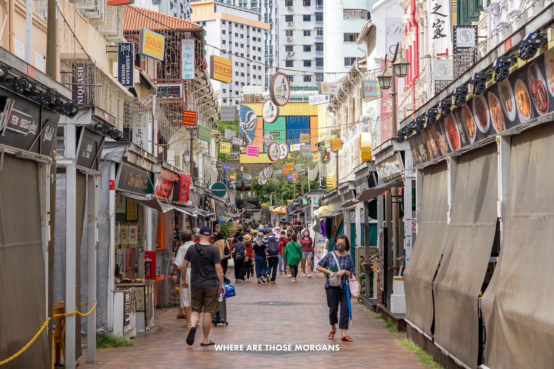People walking down a narrow street with shops and souvenirs in city