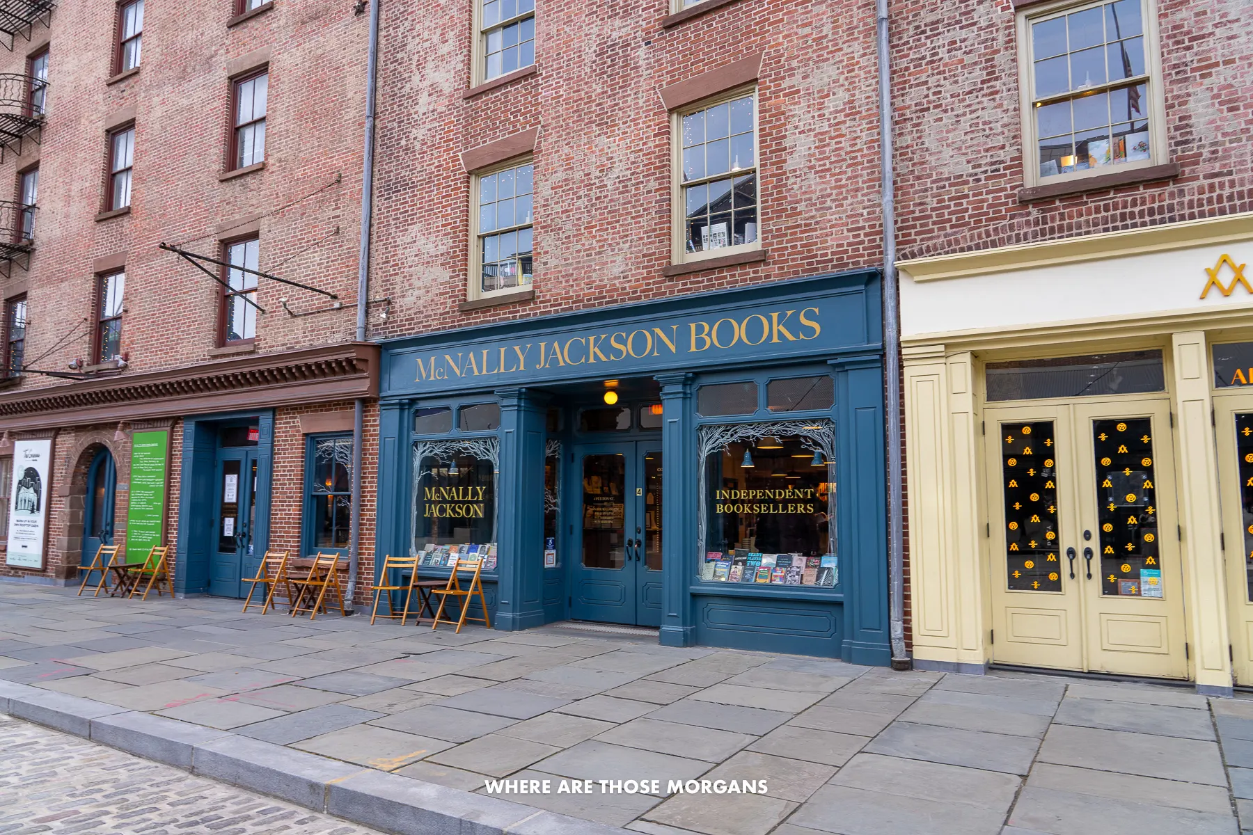 Row of brick buildings with colorful lower level facades as entrances to book stores and restaurants in Seaport