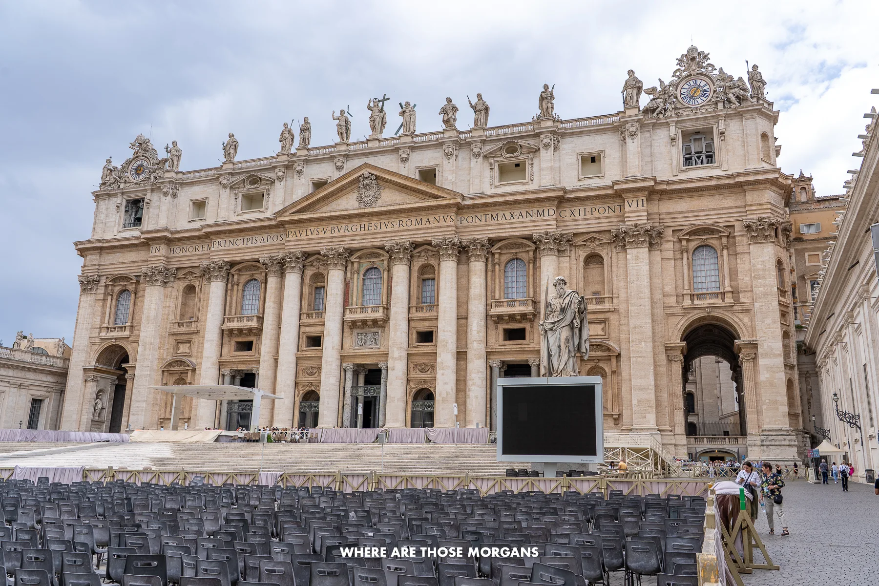 The front and side of St Peter's Basilica with lots of chairs out front