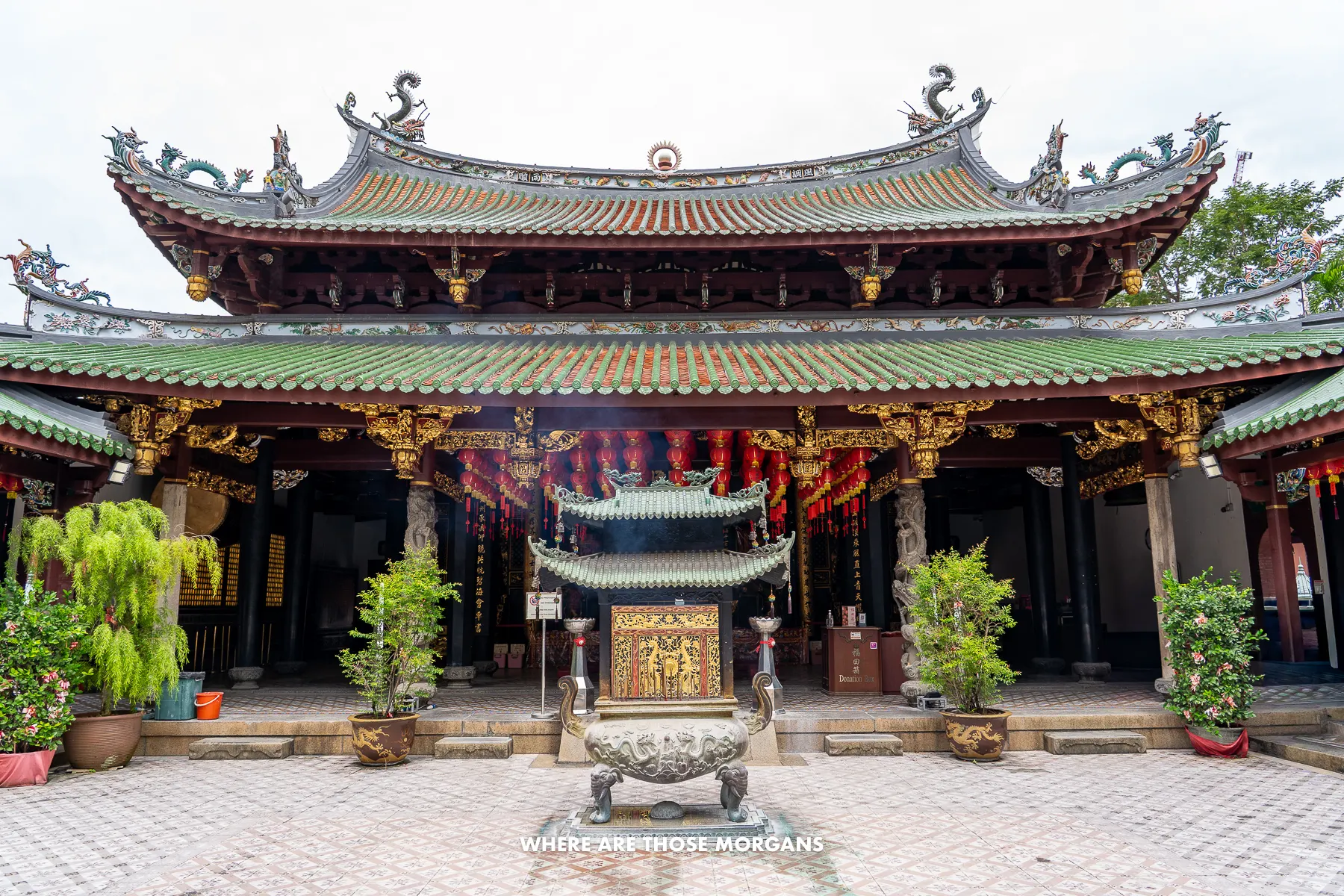 Looking at the front of a Taoist temple in Chinatown Singapore with smoke rising from burning incense