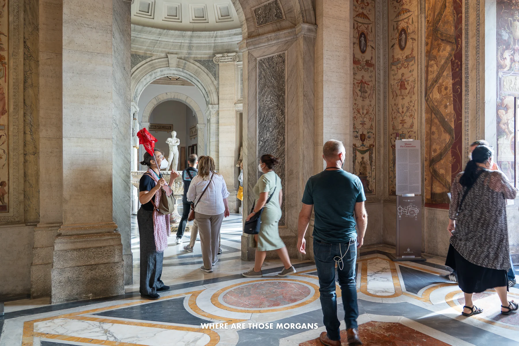Tour guide holding red flag explaining things to people in Rome
