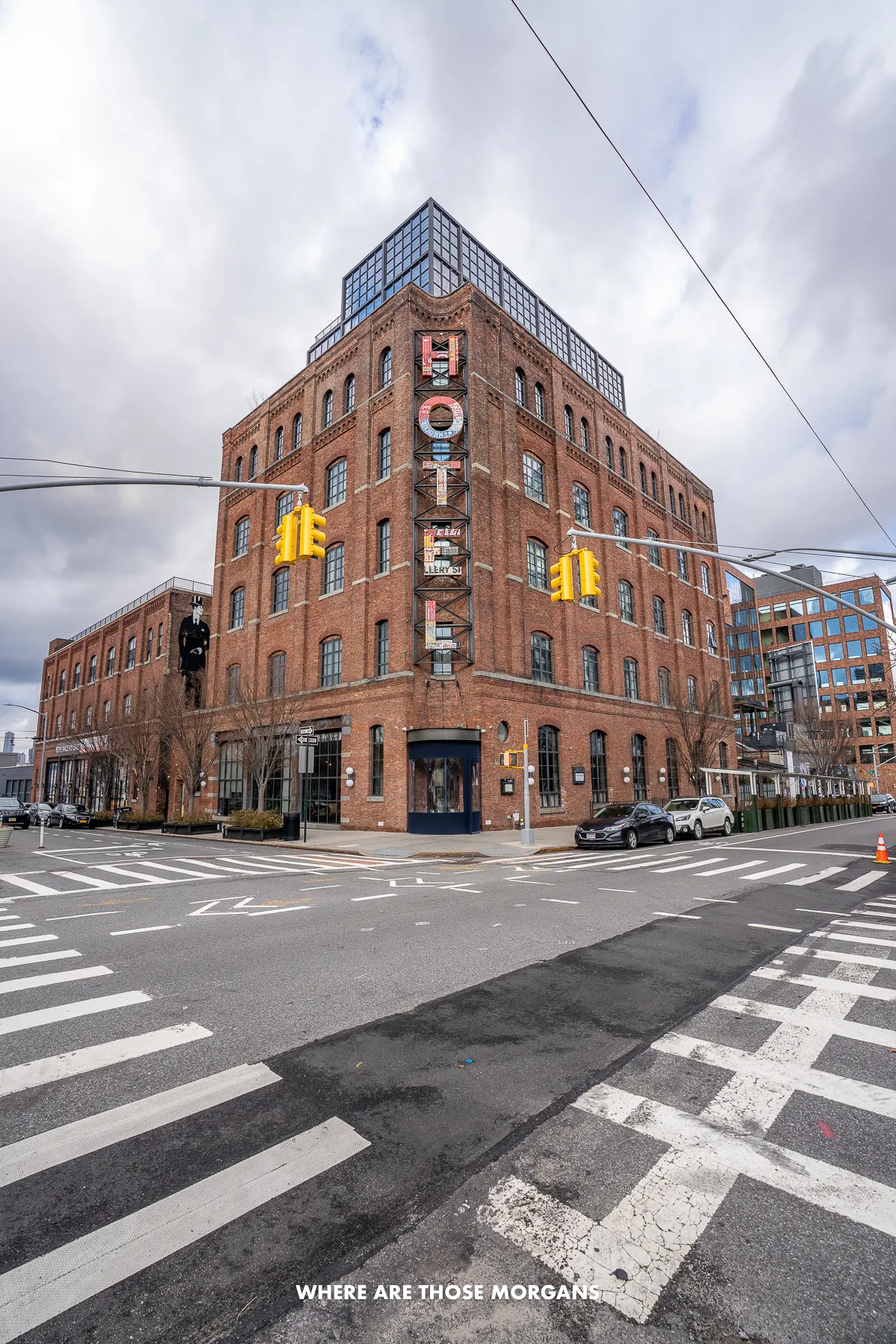 Exterior photo of the brick Wythe Hotel in Williamsburg Brooklyn behind pedestrian crossings