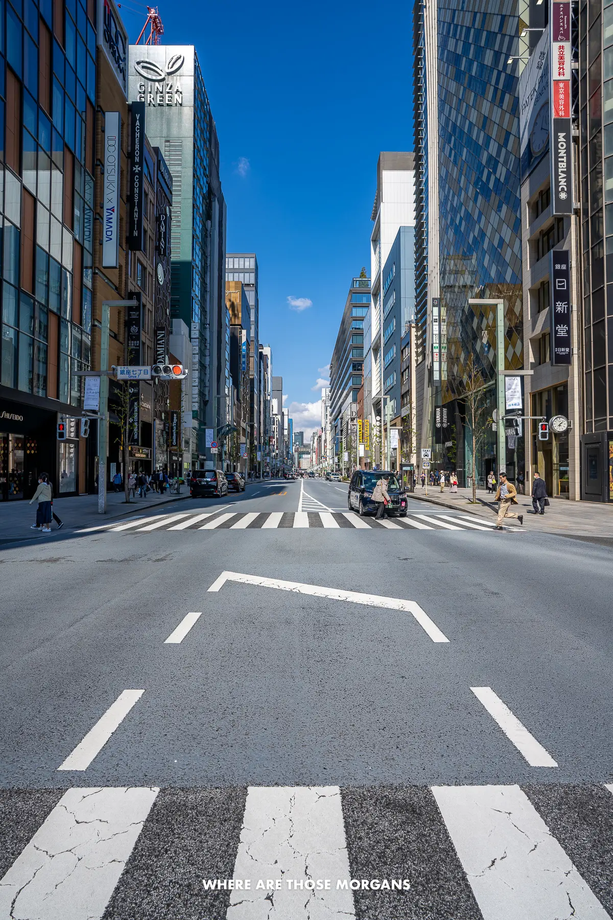Looking down a long straight street with tall skyscrapers on either side on a clear sunny day