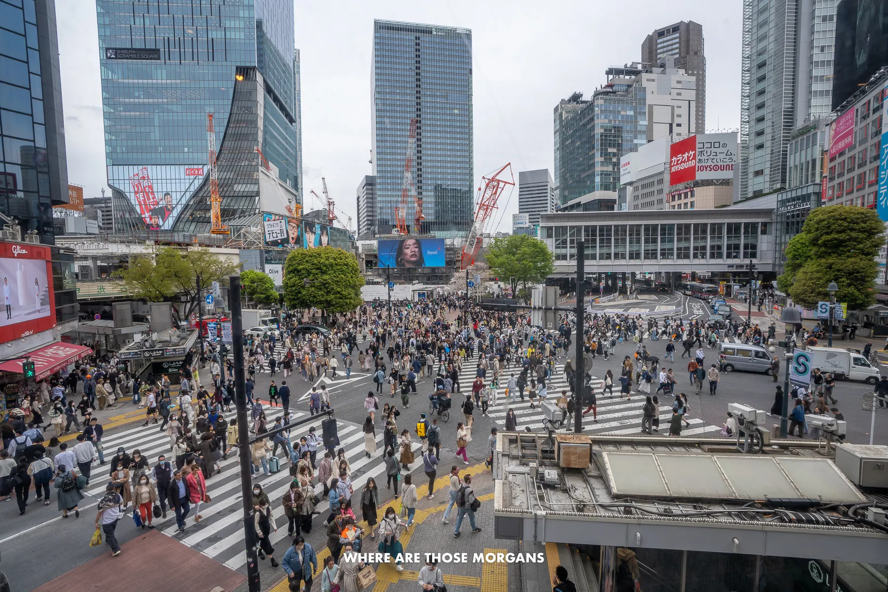 View over Shibuya Crossing X-shaped pedestrian road crossing with hundreds of people walking over the road at once