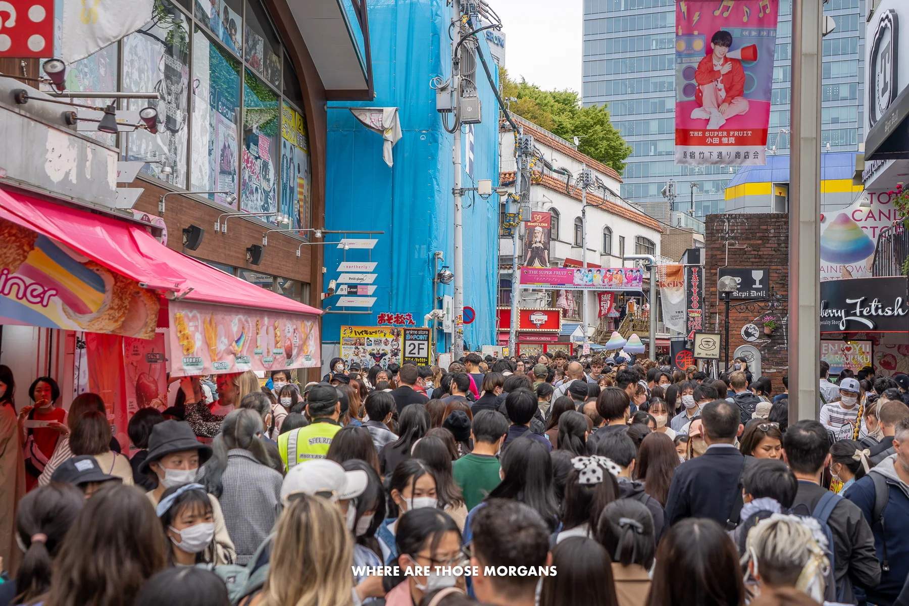 An ocean of people walking shoulder to shoulder in both directions along a narrow street in Tokyo