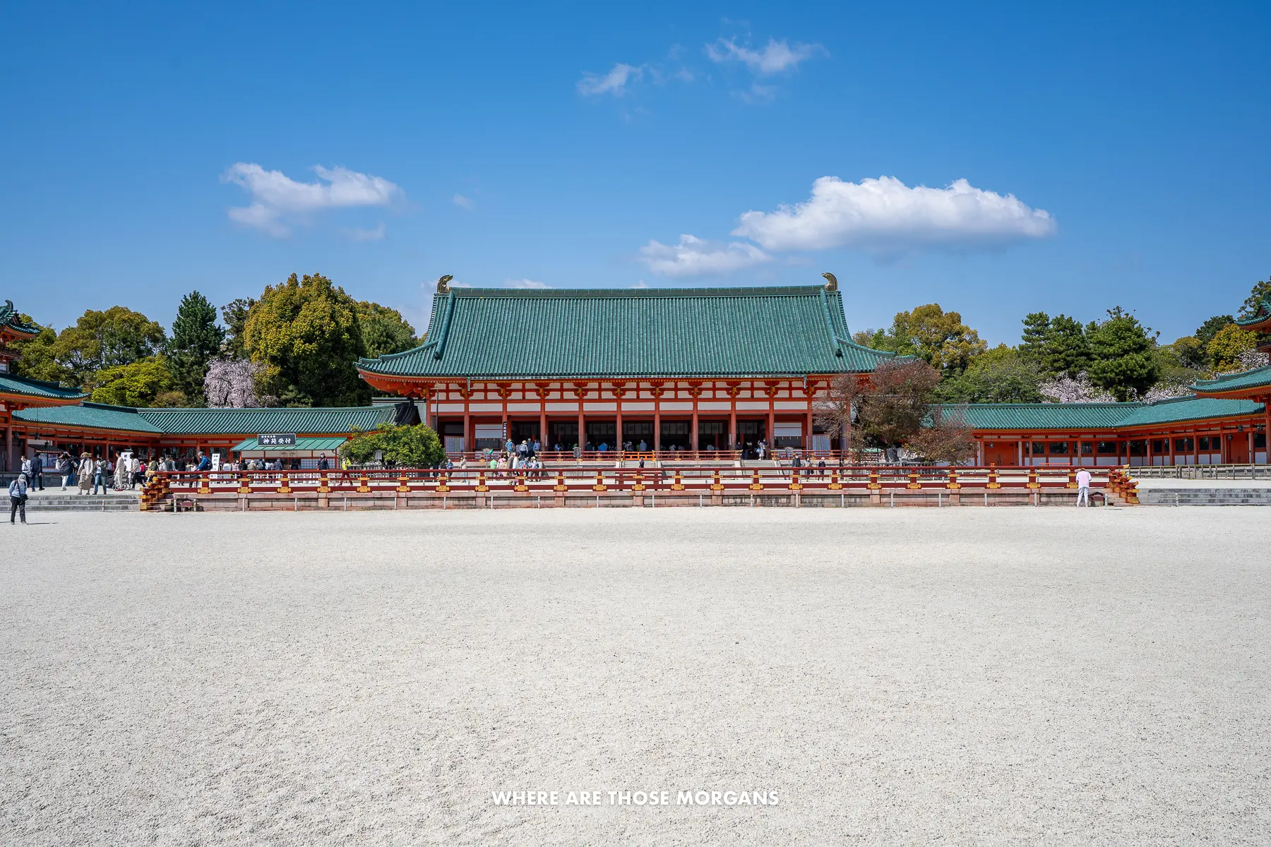 Vast stone courtyard with buildings and trees at the far side under a clear blue sky in Japan