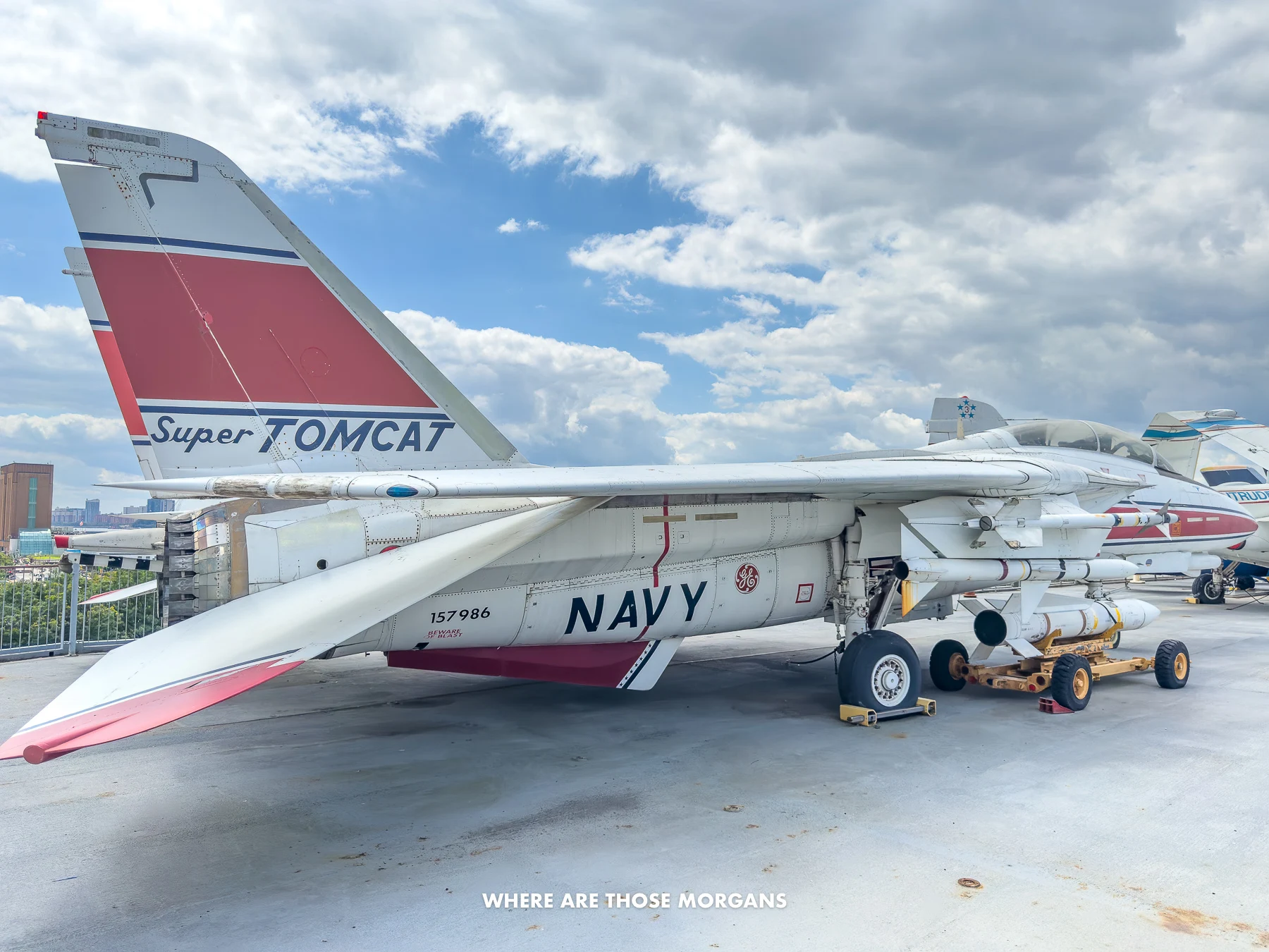 F-14 Super Tomcat sat on the flight deck of an aircraft carrier under a cloudy sky