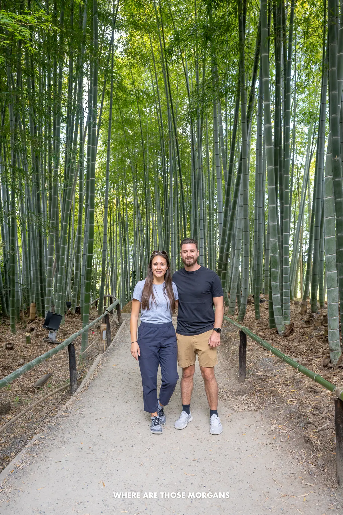 Mark and Kristen from Where Are Those Morgans standing together for a photo on a narrow path flanked by tall green bamboo trees
