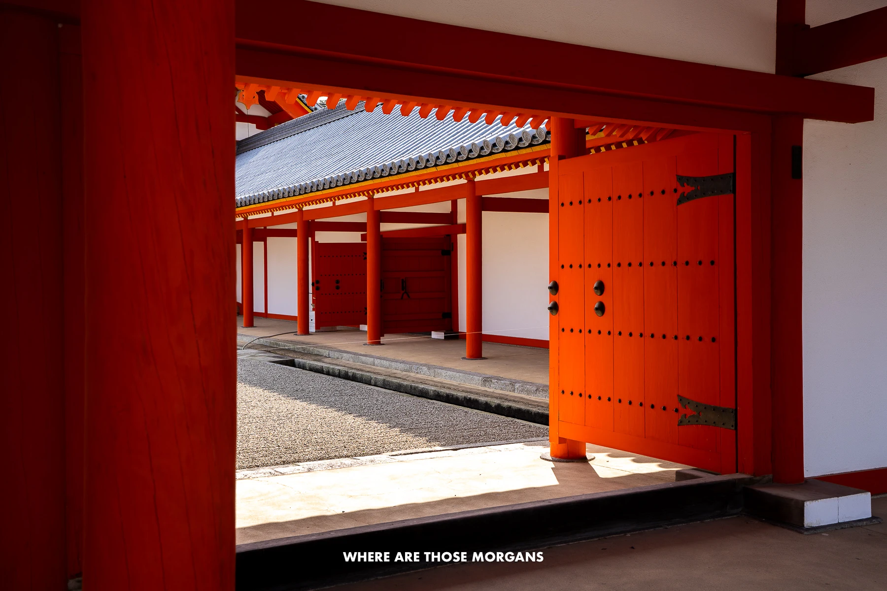 Vermilion red colored doors opening into Kyoto Imperial Palace grounds on a sunny day
