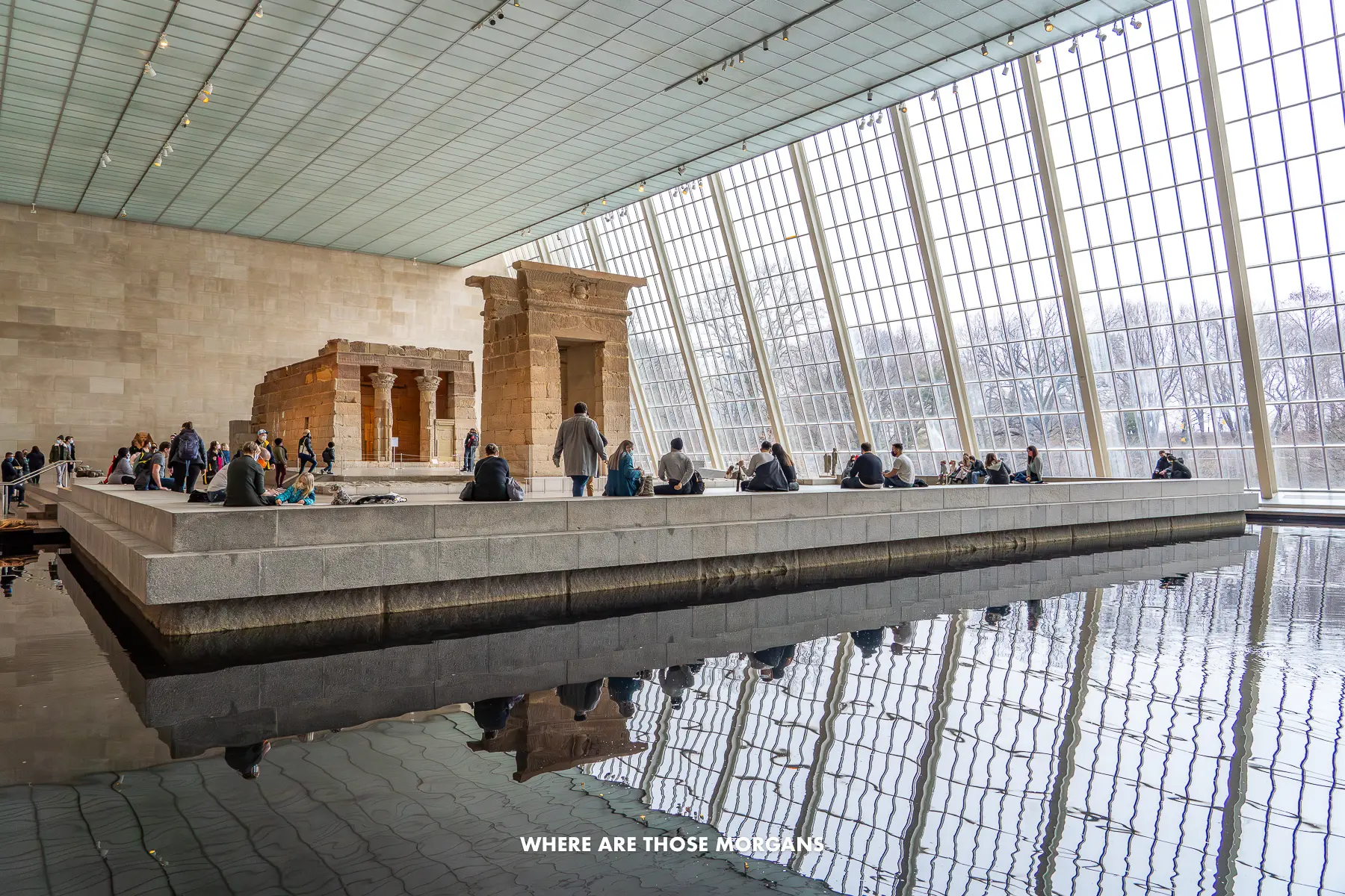 Water feature and Egyptian exhibits next to enormous glass windows inside The Met in NYC