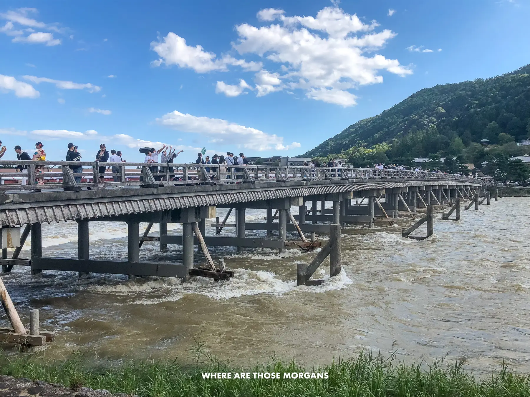 Long wooden bridge crossing a wide river under a clear blue sky in central Japan