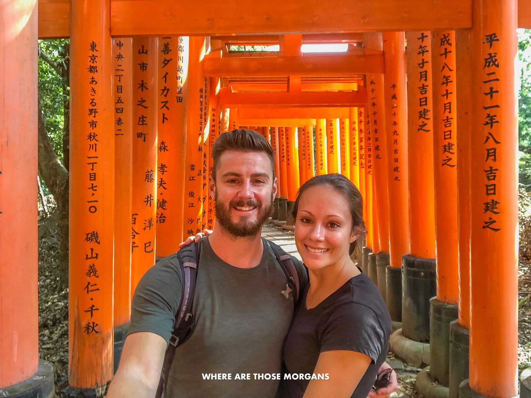 Mark and Kristen from Where Are Those Morgans taking a selfie with the red torii gates of Inari Fushimi Taisha in Kyoto Japan