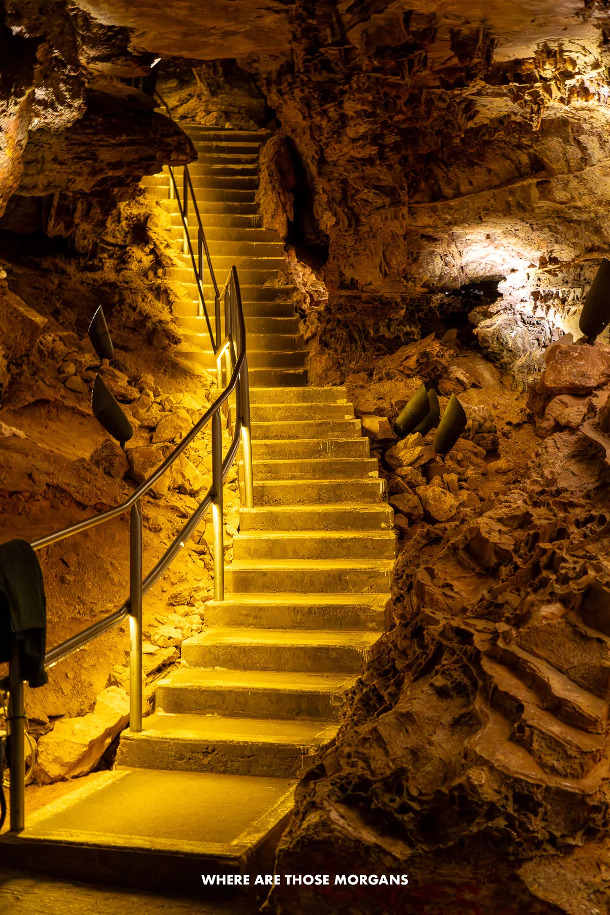 Illuminated, curving staircase leading up through a cave