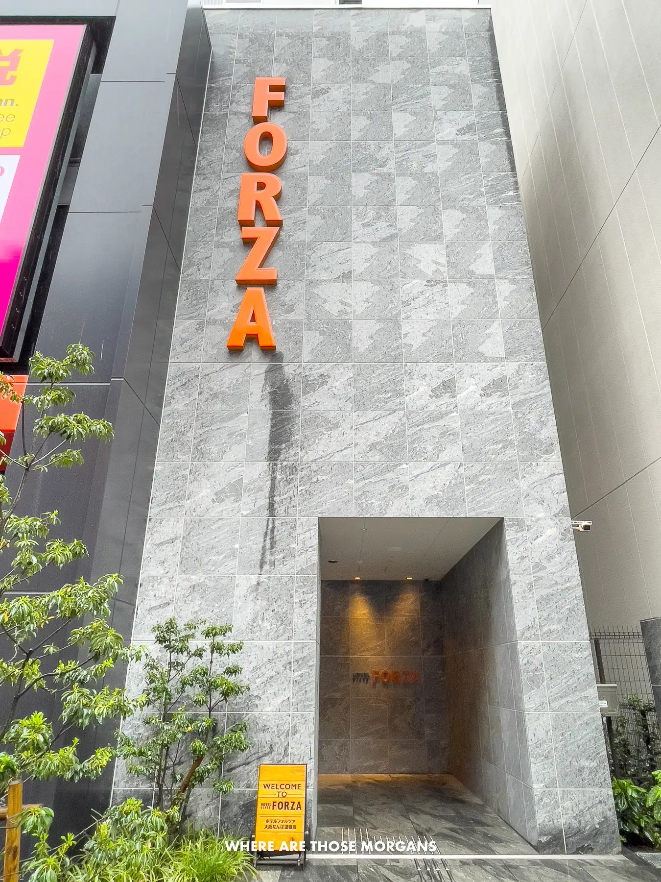 Photo of the Forza Hotel building entrance in Dotonbori, Osaka with orange letters going down spelling out Forza