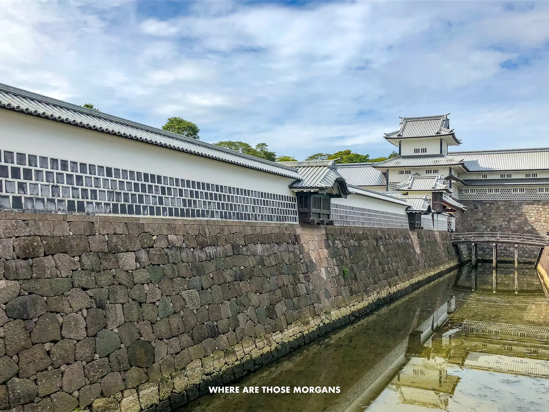 Stone fortifications and moat at Kanazawa Castle on a sunny day
