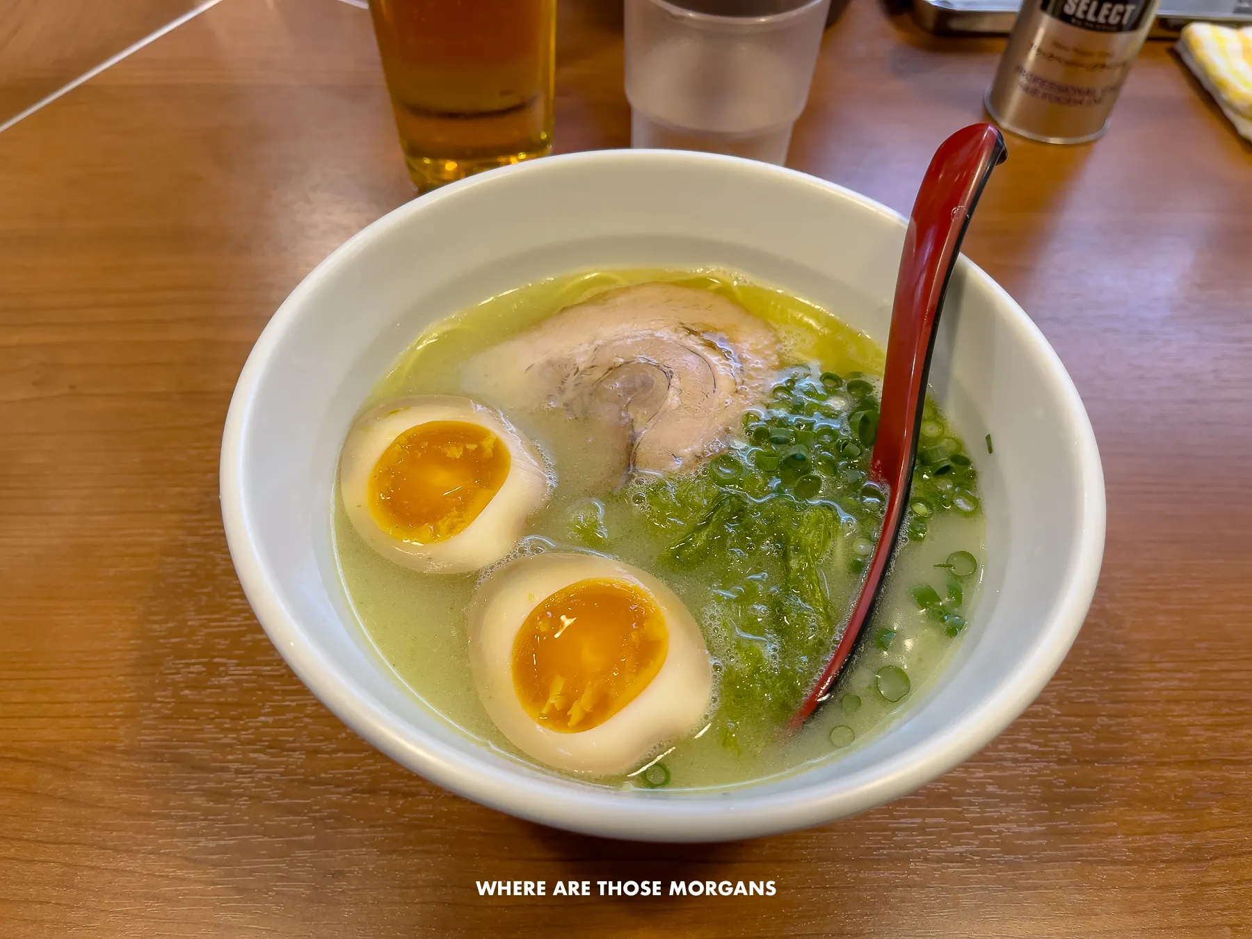 Bowl of ramen with eggs, pork and broth on a wooden table in Japan