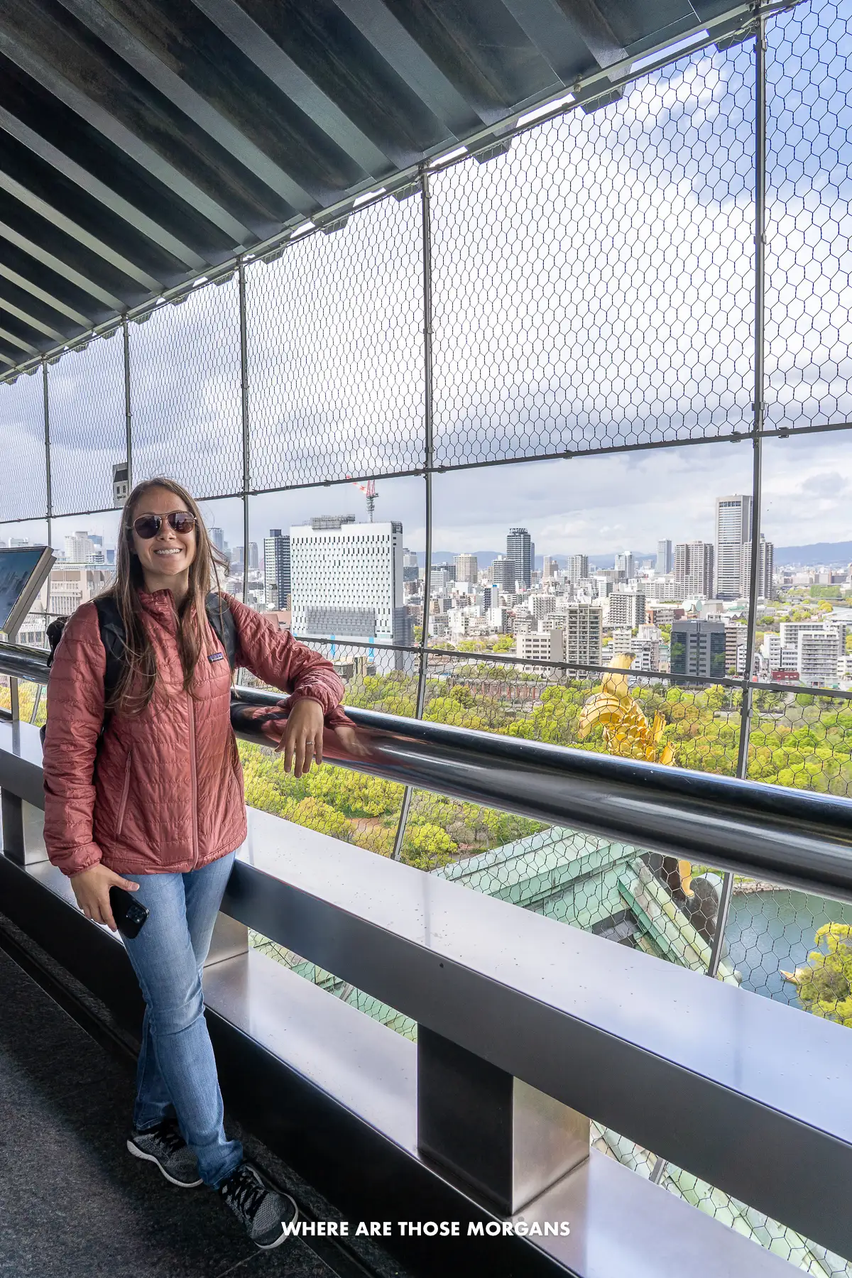 Kristen from Where Are Those Morgans on a balcony at the top of a castle with views over a city in Japan