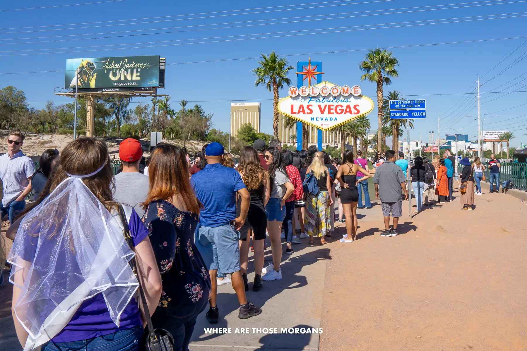 Long queue of people waiting on a hot morning to get a photo with the welcome to Las Vegas sign