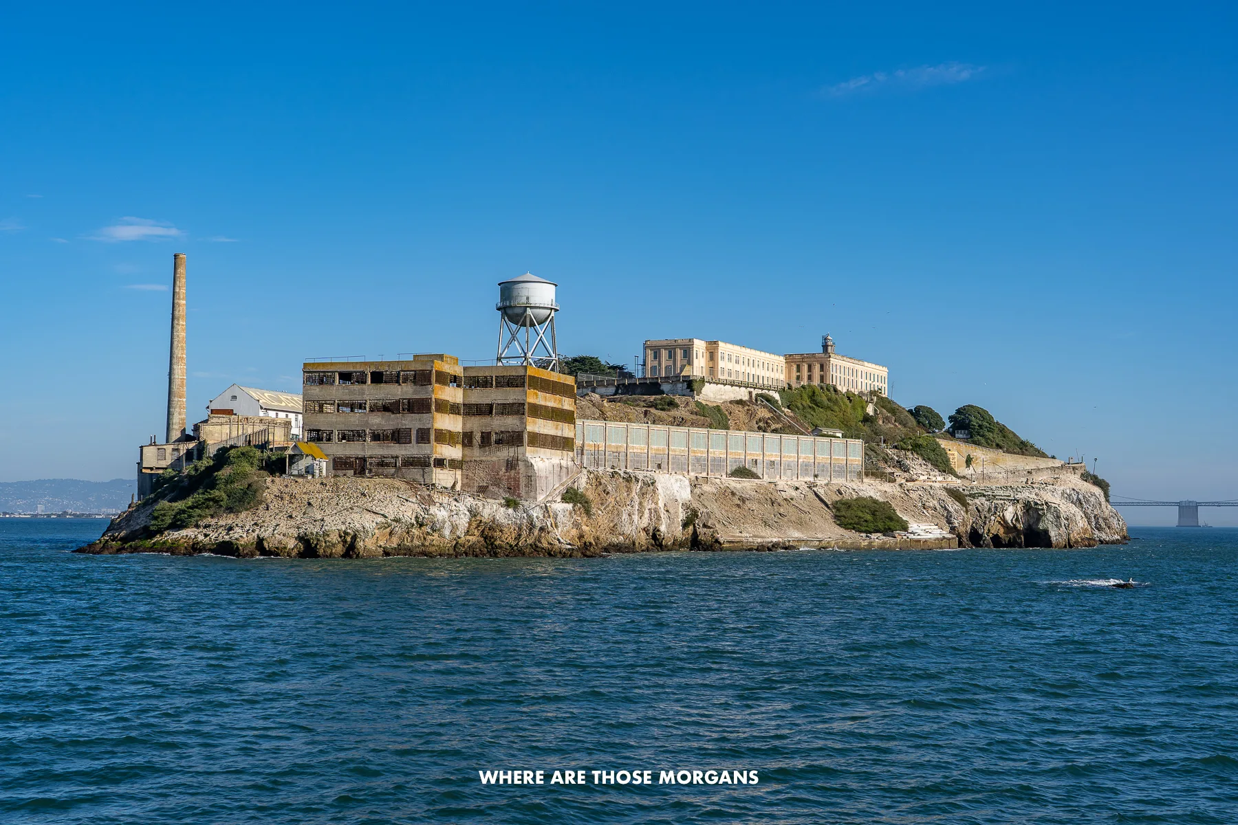 Close up photo of Alcatraz Island surrounded by water on a clear sunny day