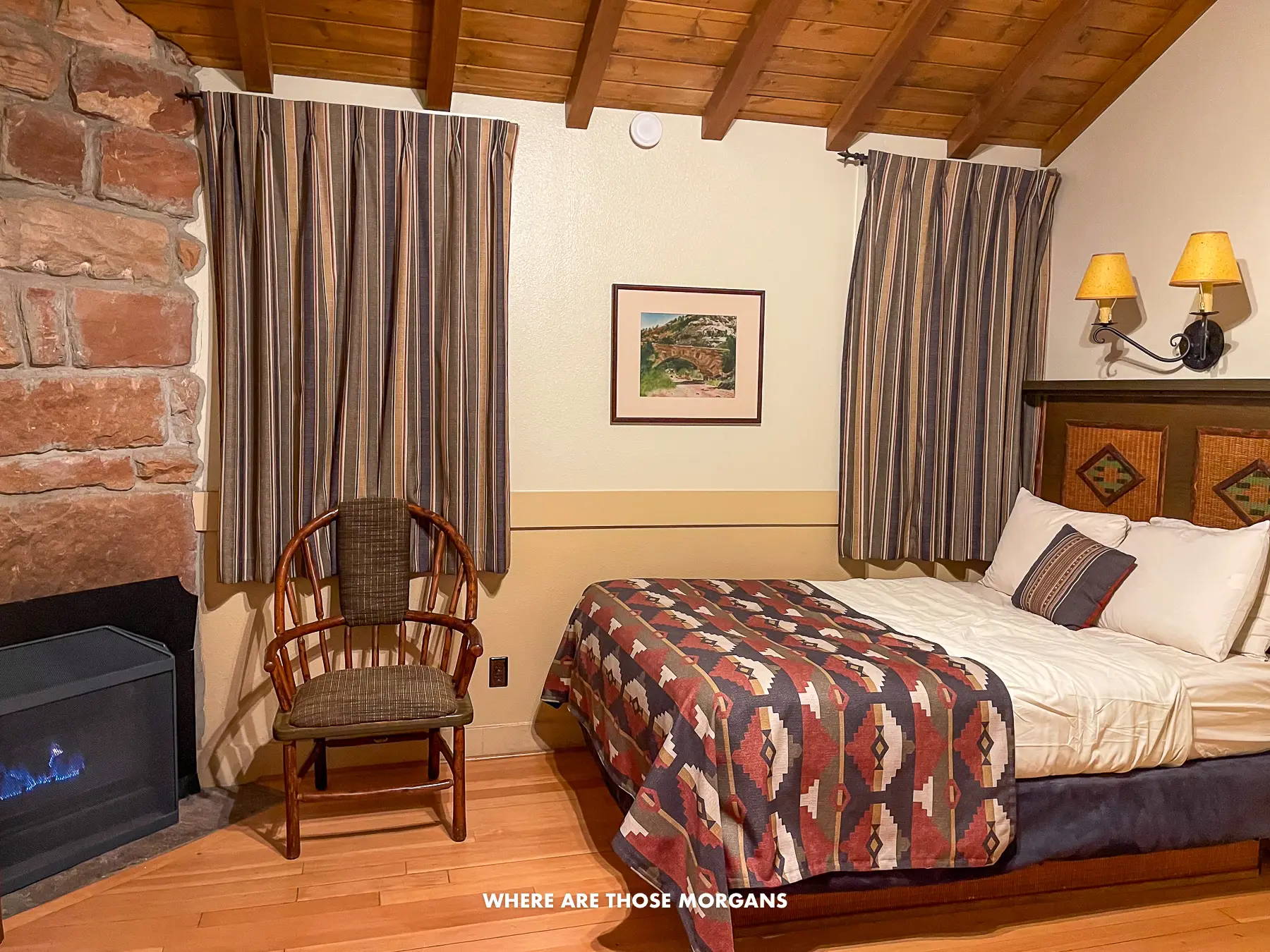 Inside a guest cabin at Zion Lodge with a bed, chair and fireplace