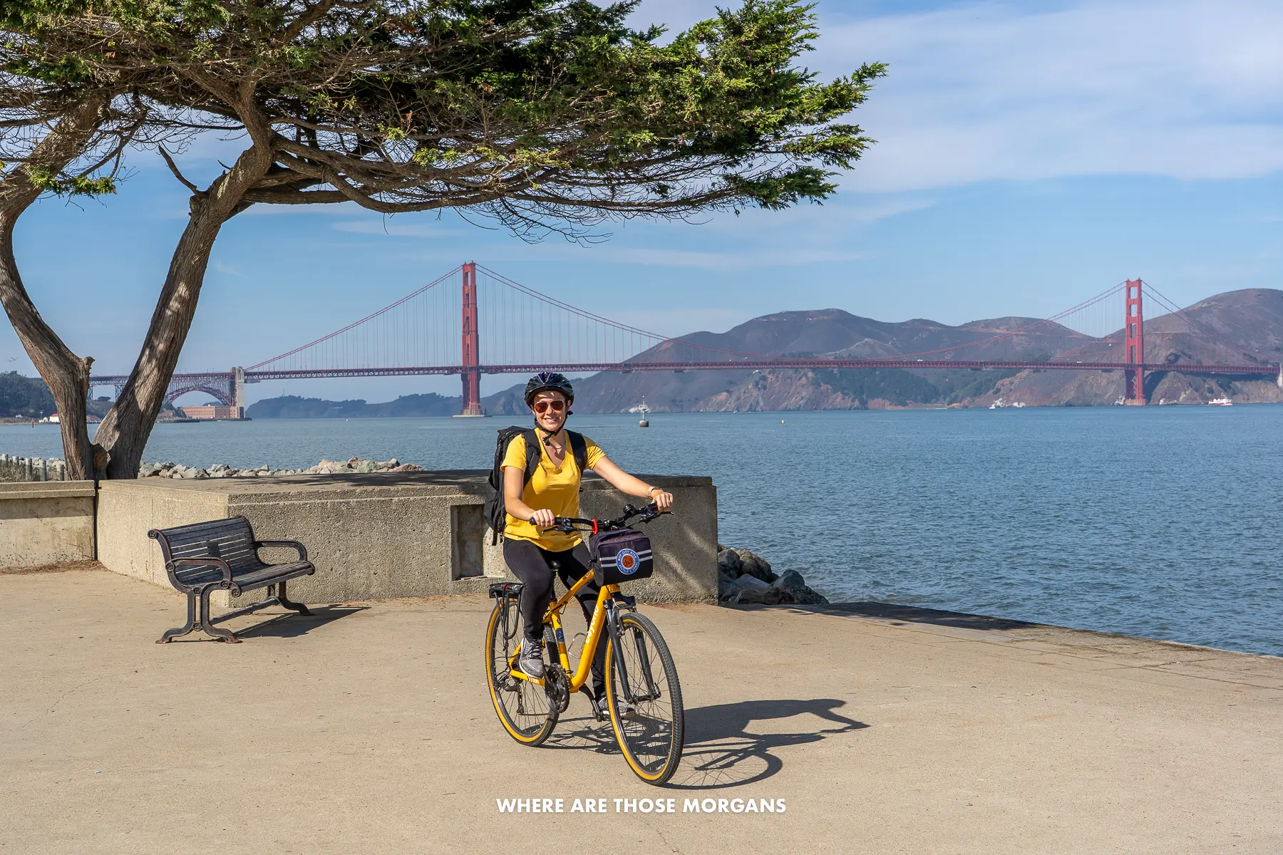 Kristen from Where Are Those Morgans riding a rental bike along the SF bay front with Golden Gate Bridge views behind