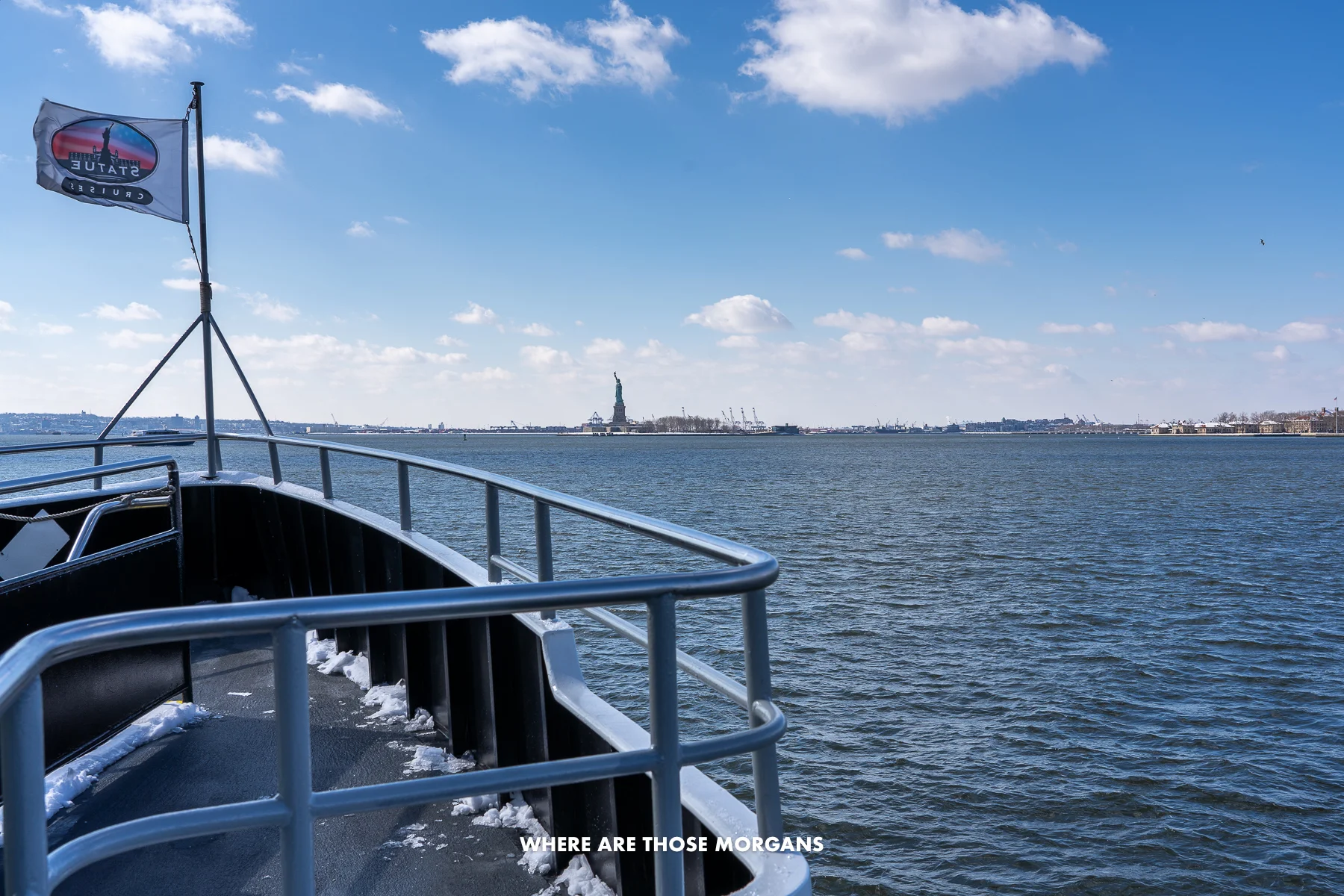 Open deck of a ferry on the water heading for the Statue of Liberty