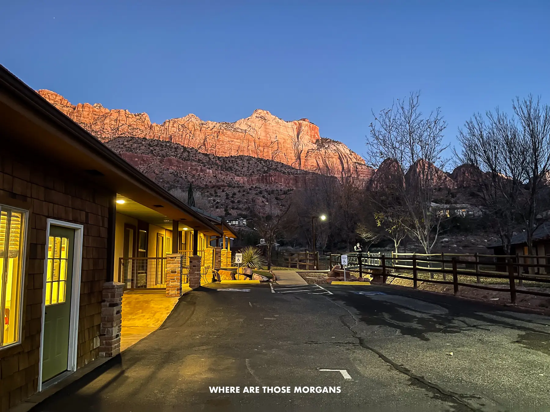 Looking at a row of motel rooms towards red rock mountains at dawn in Utah