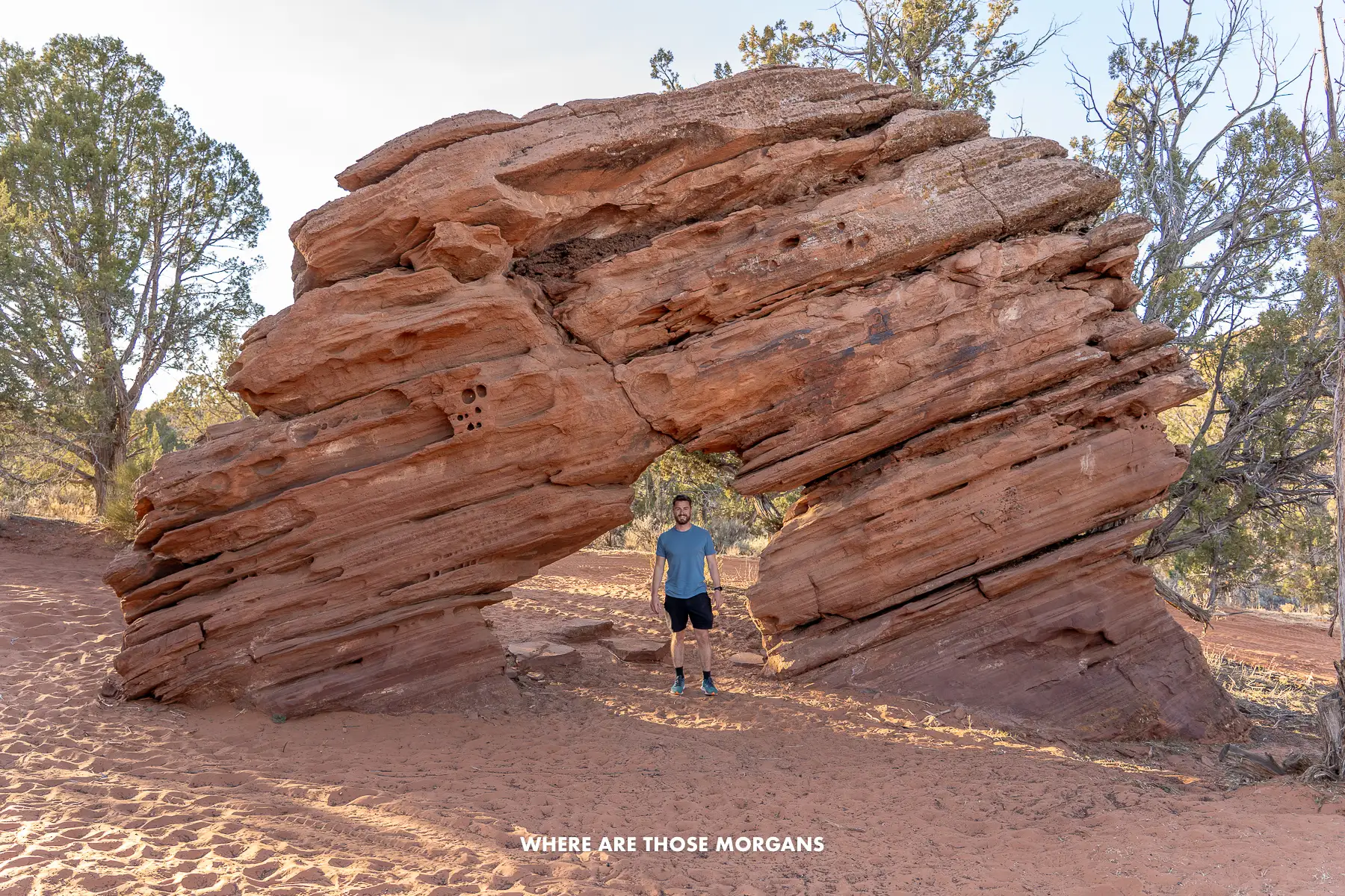 Mark from Where Are Those Morgans standing underneath a thick sandstone arch near Kanab