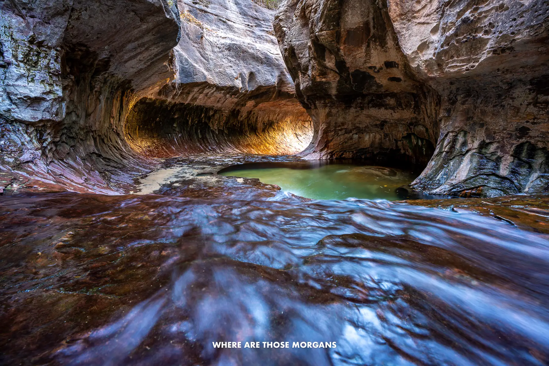 The end of The Subway hike in Zion with a tunnel flooding with light and small turquoise colored pools in rock