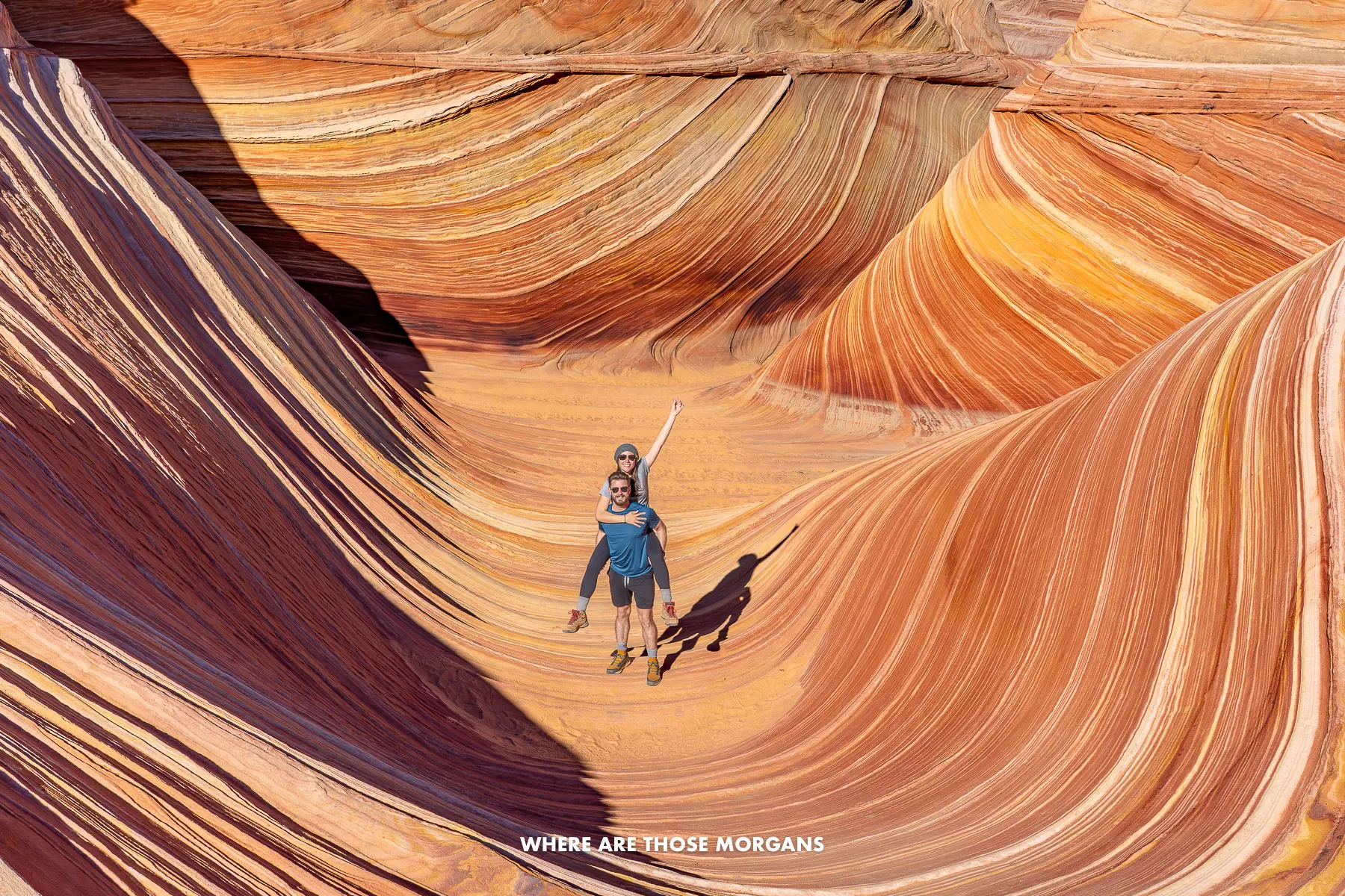 Mark and Kristen from Where Are Those Morgans together alone inside The Wave in Arizona surrounded by swirling red, orange and white sandstone layers