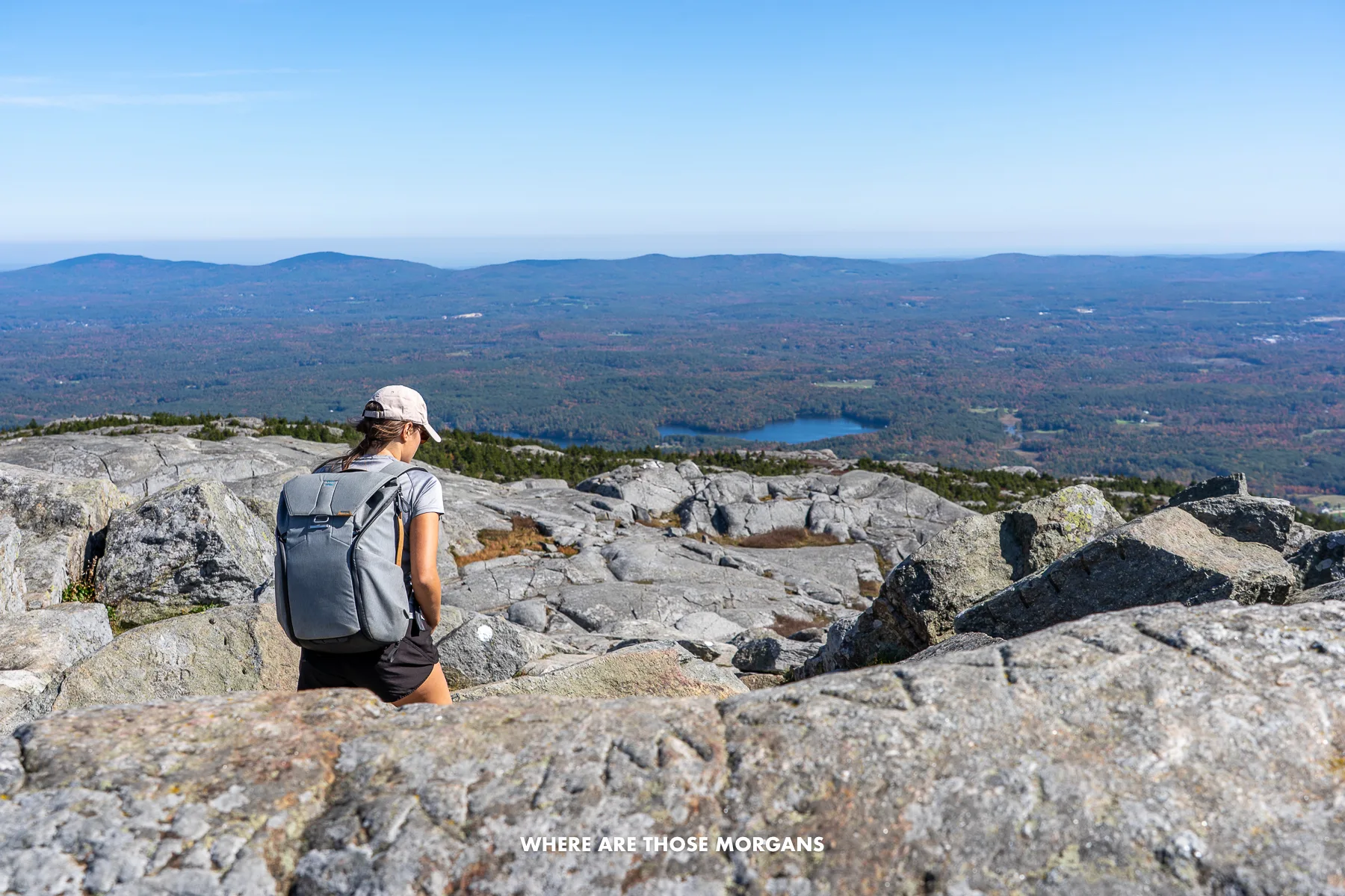 Kristen from Where Are Those Morgans hiking through rocks on a trail in New Hampshire
